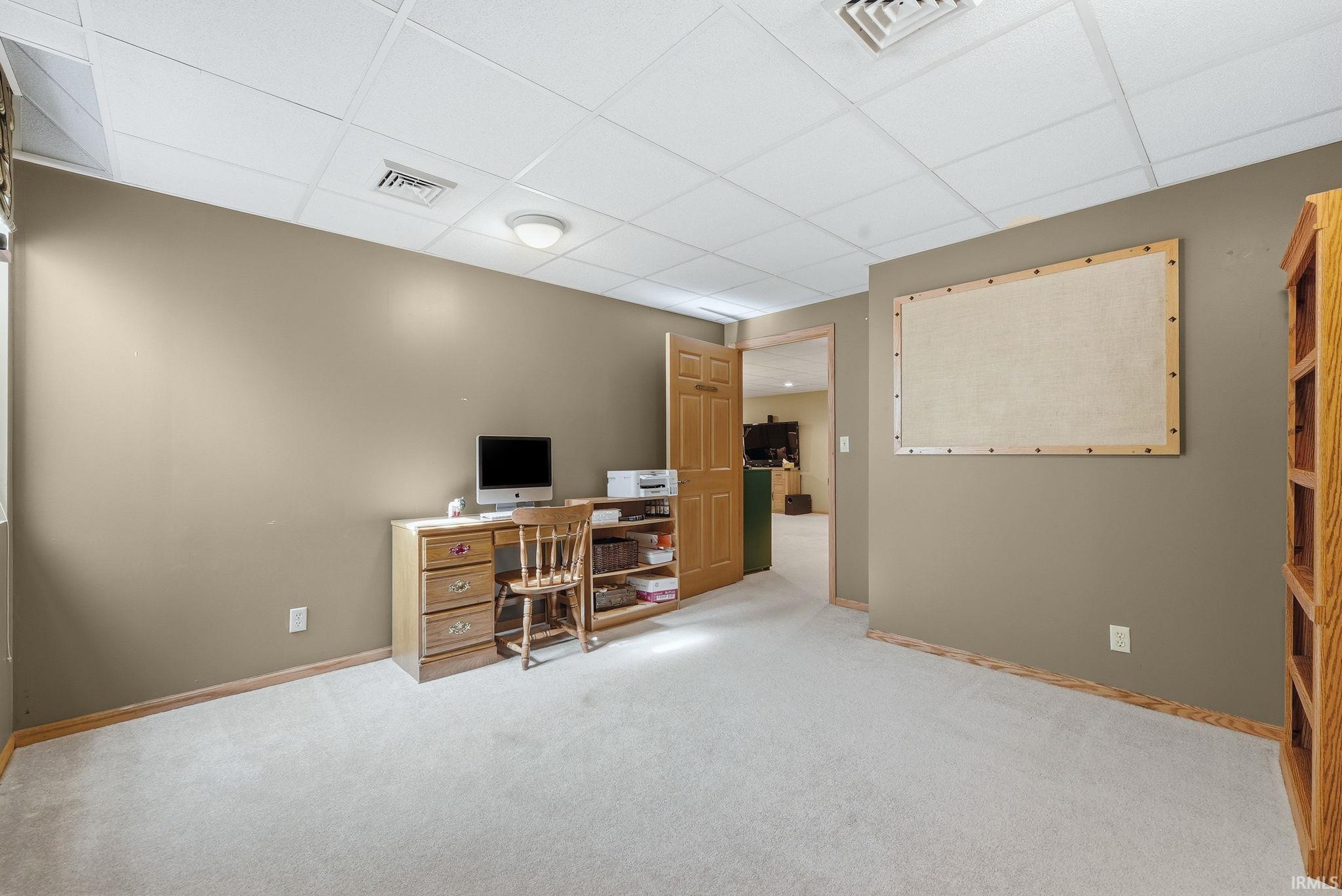 Carpeted room with a drop ceiling and recessed lighting