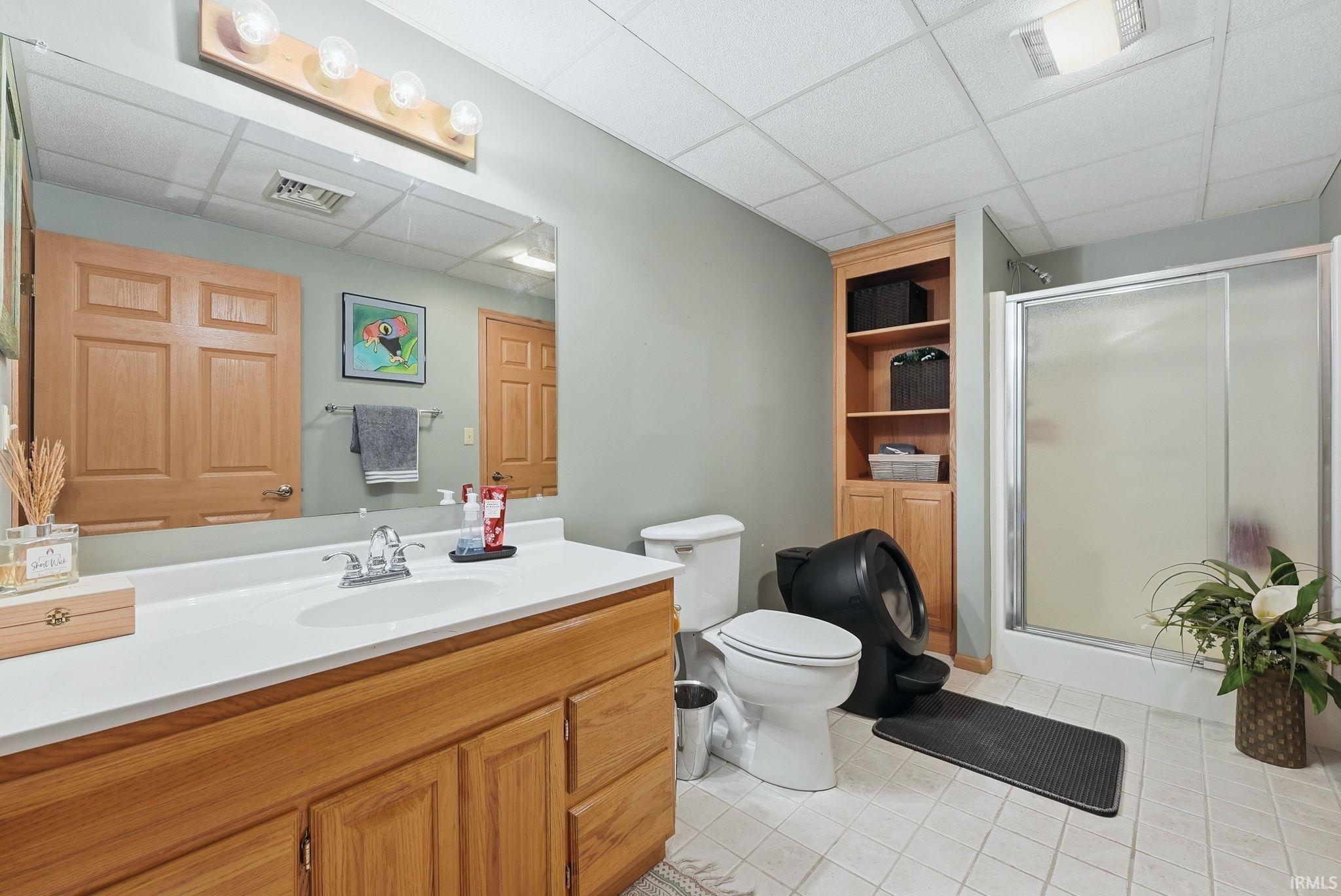Bathroom featuring a wood-finish vanity with a white countertop, an integrated sink, and a chrome faucet