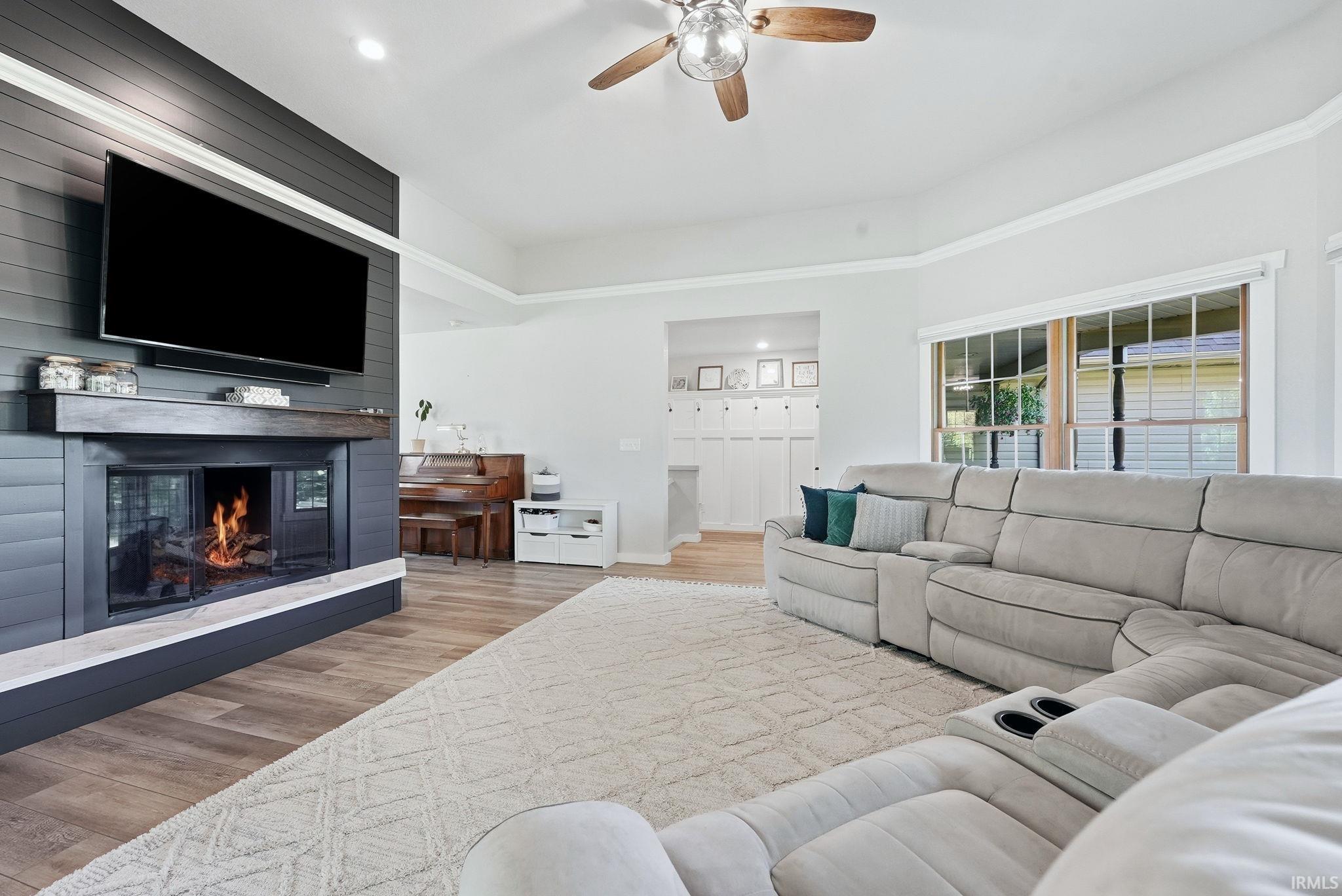 Spacious living area featuring a prominent shiplap fireplace with a wood mantel