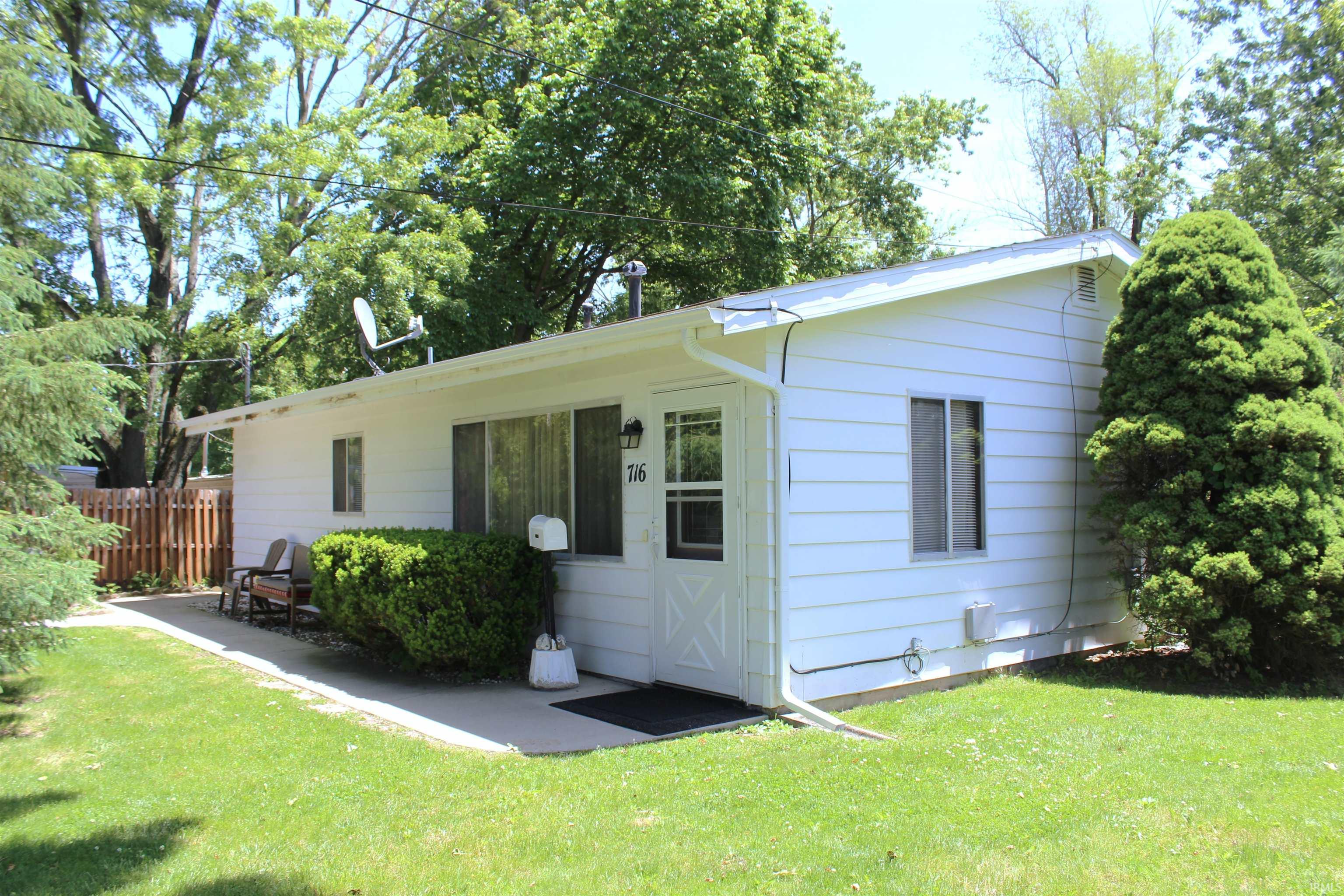 Single-story residence featuring white siding, a covered front porch, and a gable roofline