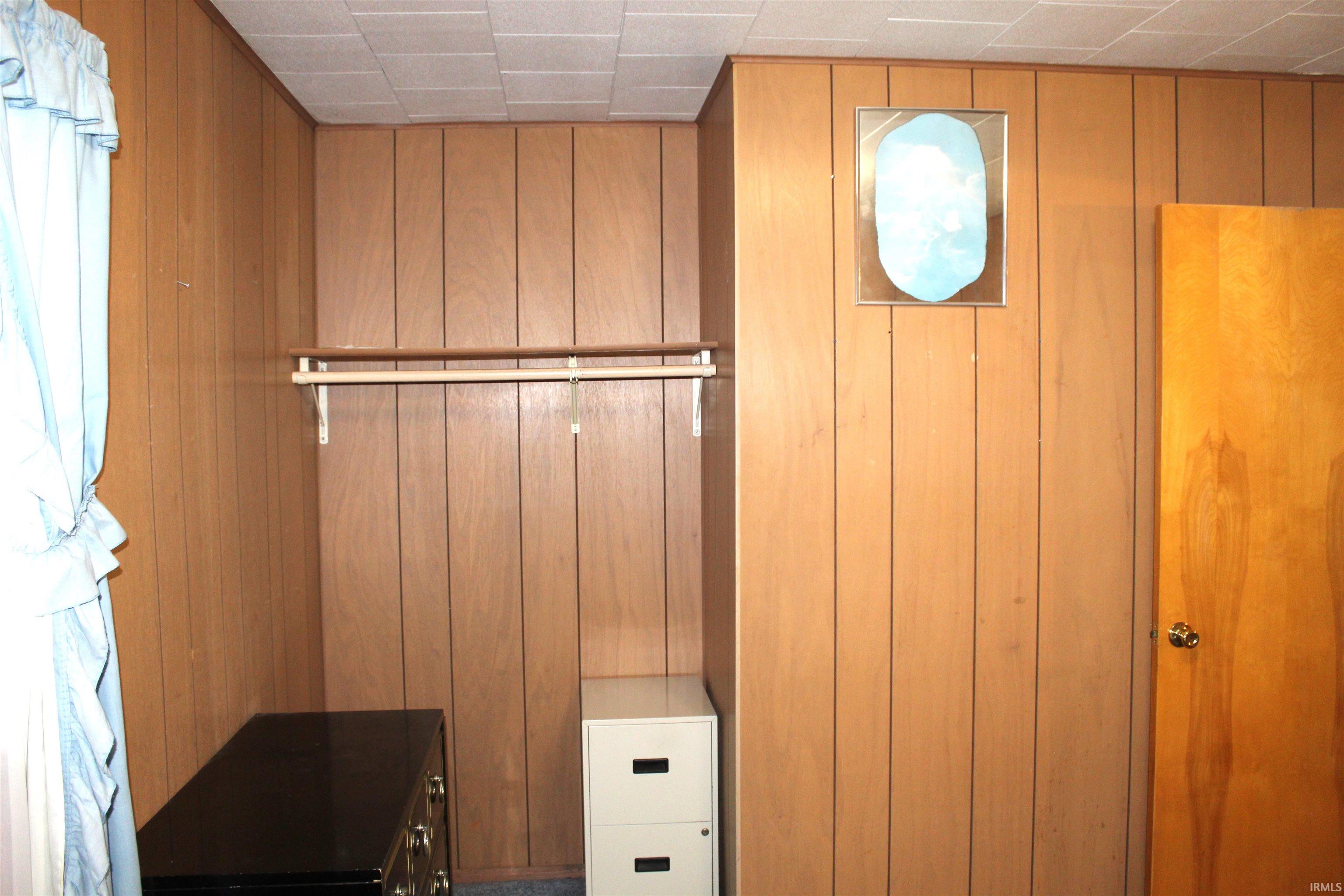 Interior space featuring wood-finish paneling and a drop ceiling
