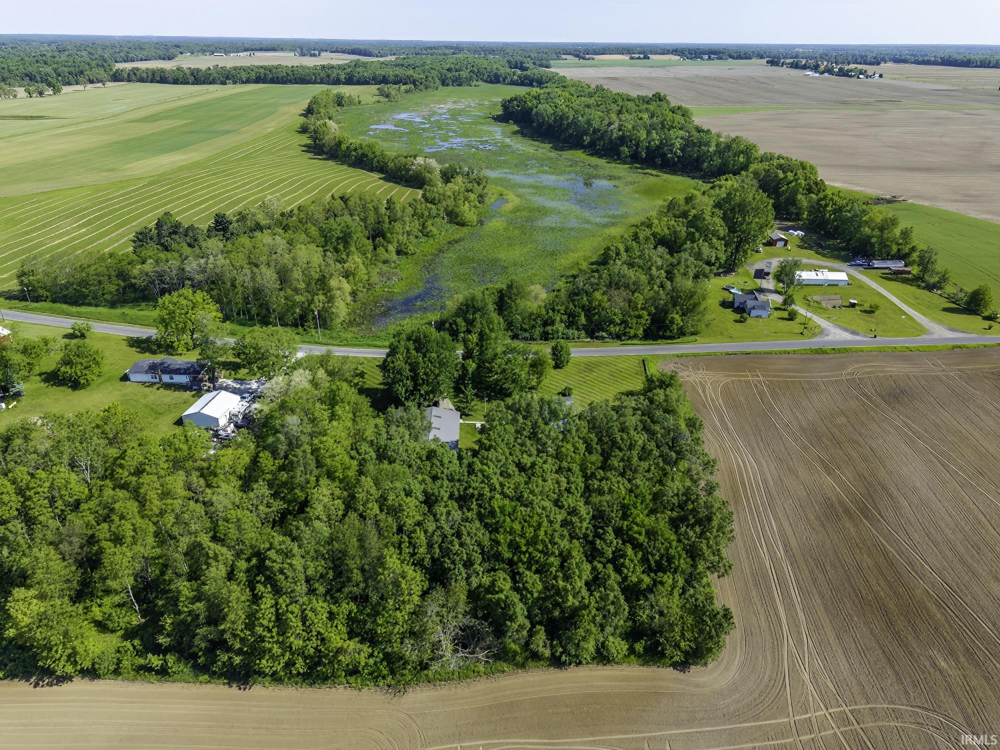 Aerial perspective showcasing a rural property with surrounding agricultural fields and natural wetlands