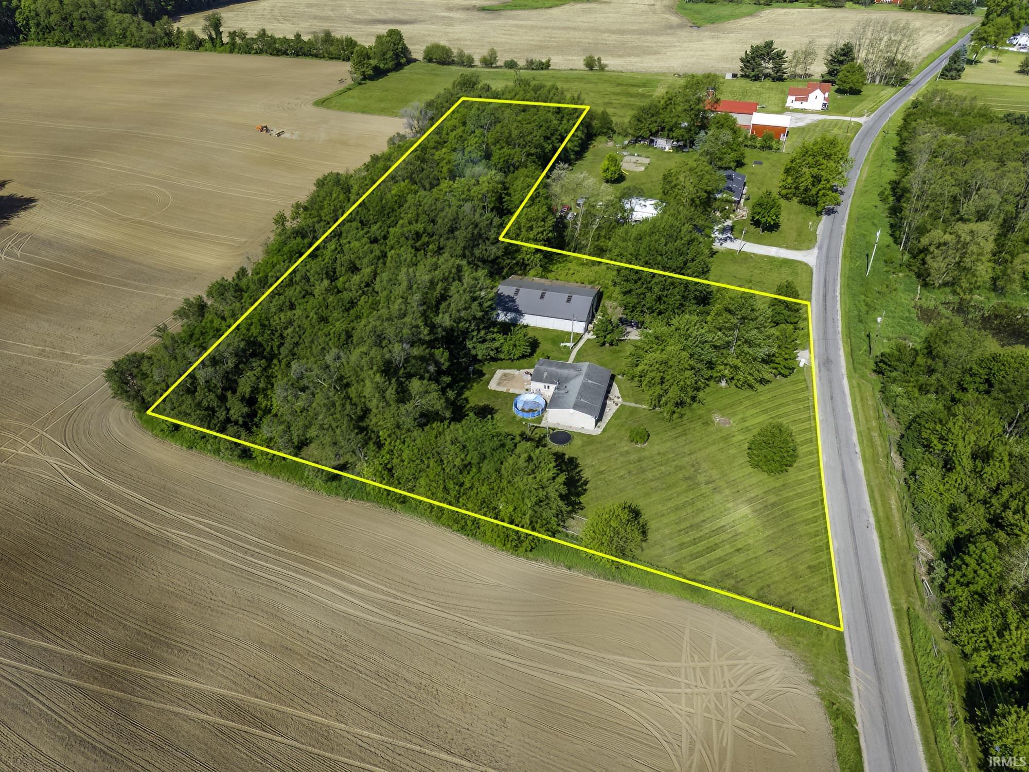 Expansive parcel featuring a main residence, an additional auxiliary structure, and a large wooded area