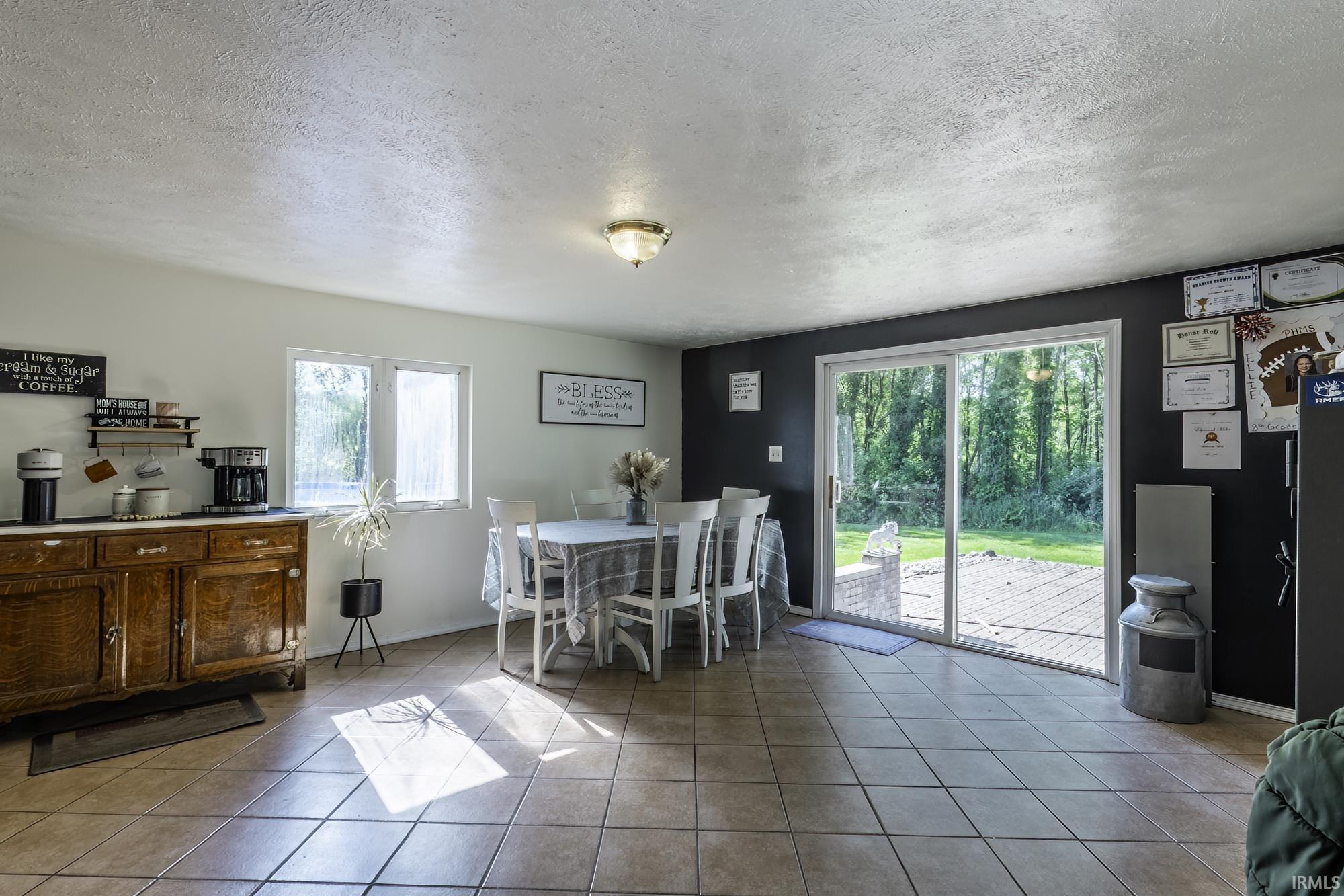 Tile flooring throughout, featuring a dining area with direct access to the outdoor space via sliding glass doors