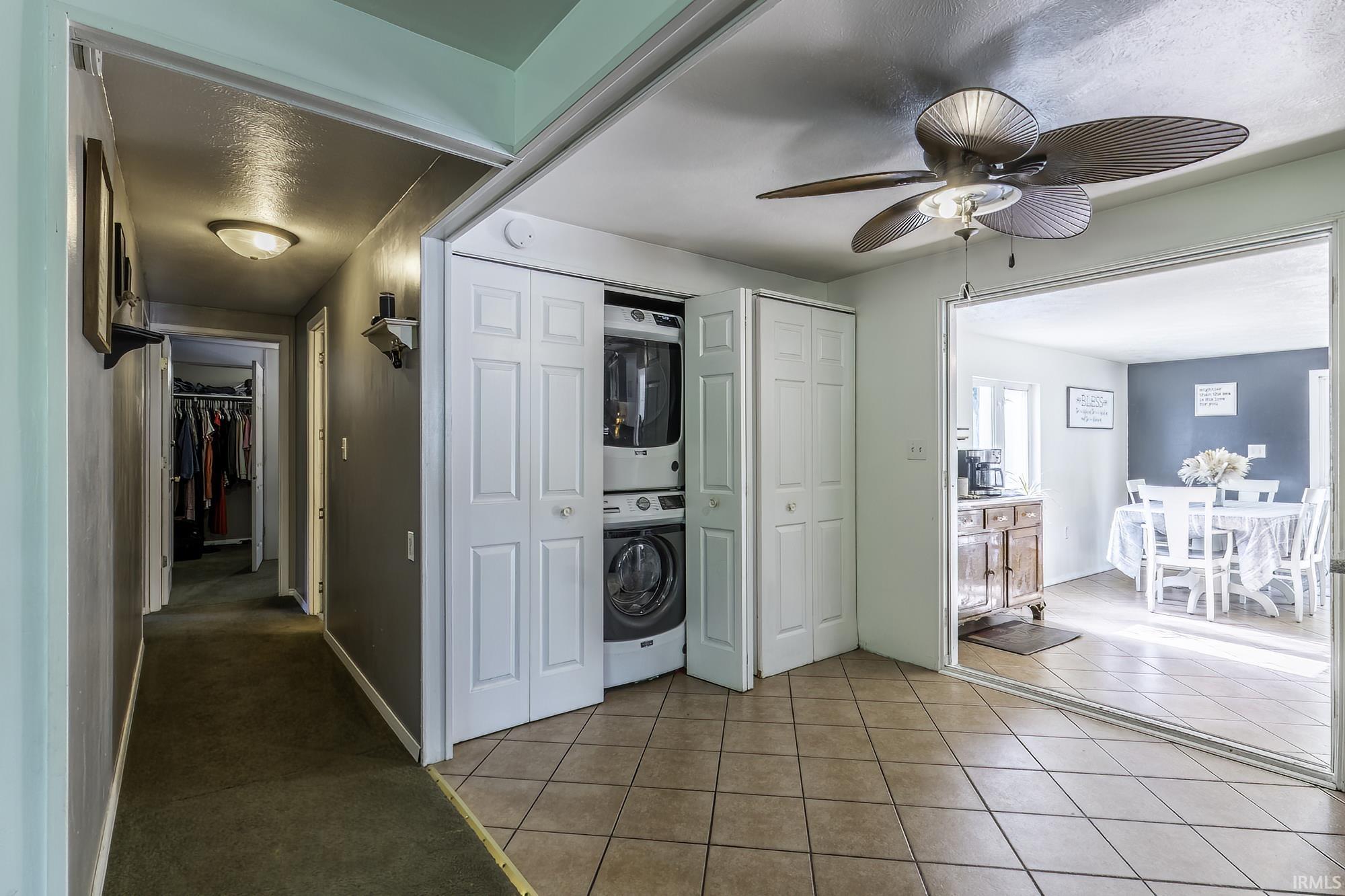 Tiled flooring extending into an open living area with a ceiling fan