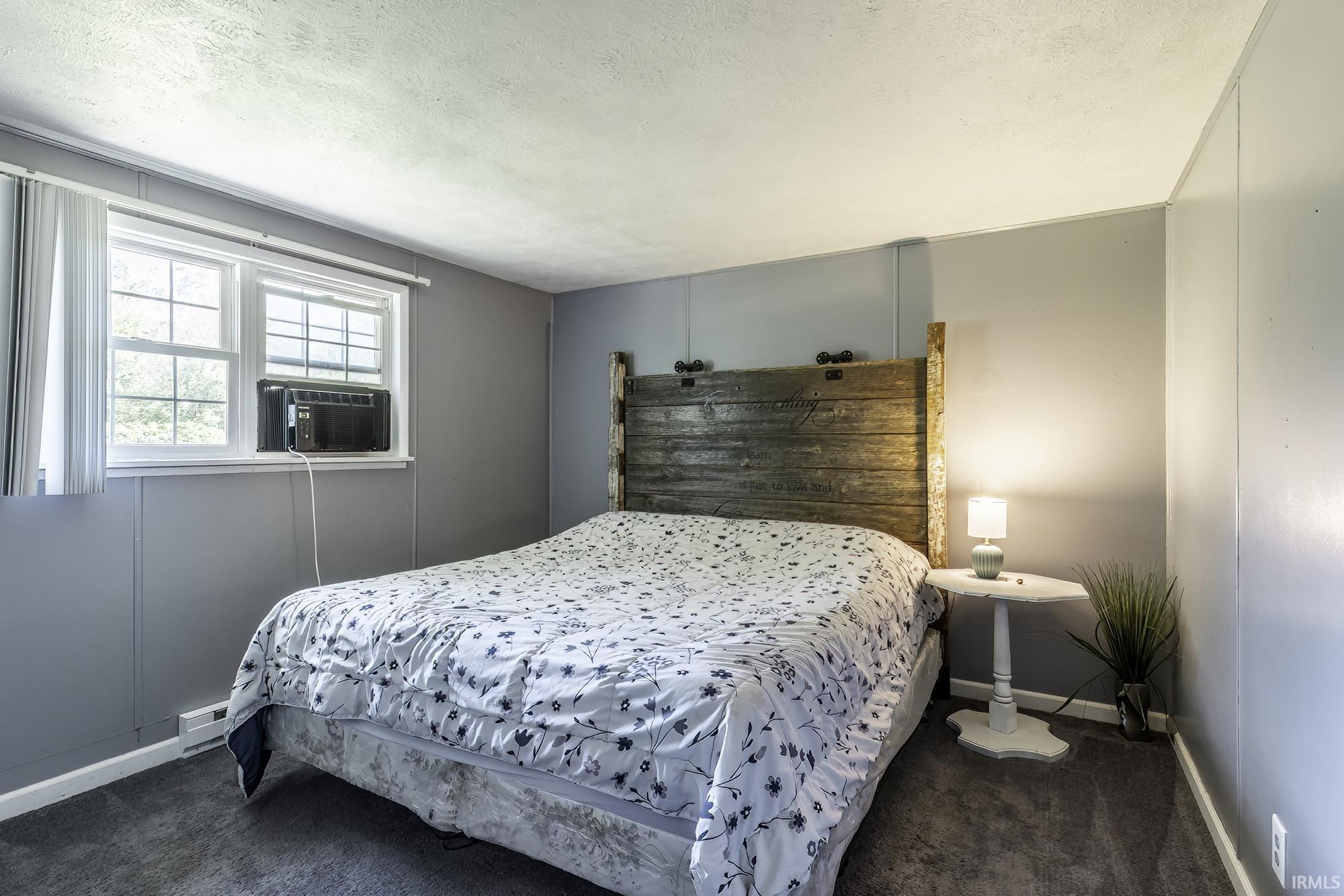 Carpeted room featuring light gray paneling, white trim, and a double window