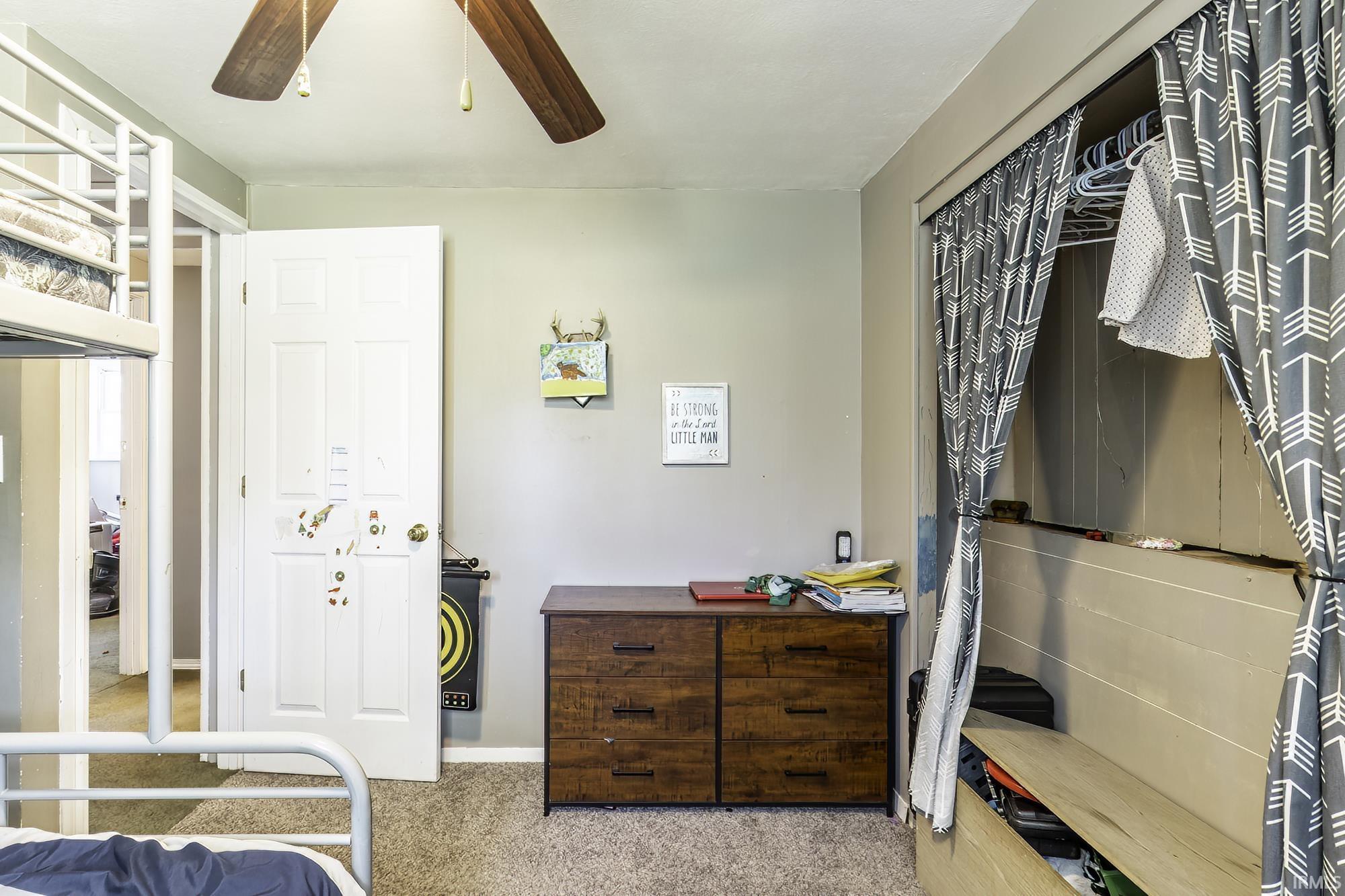 Bedroom featuring light-colored wall paint and textured carpeting