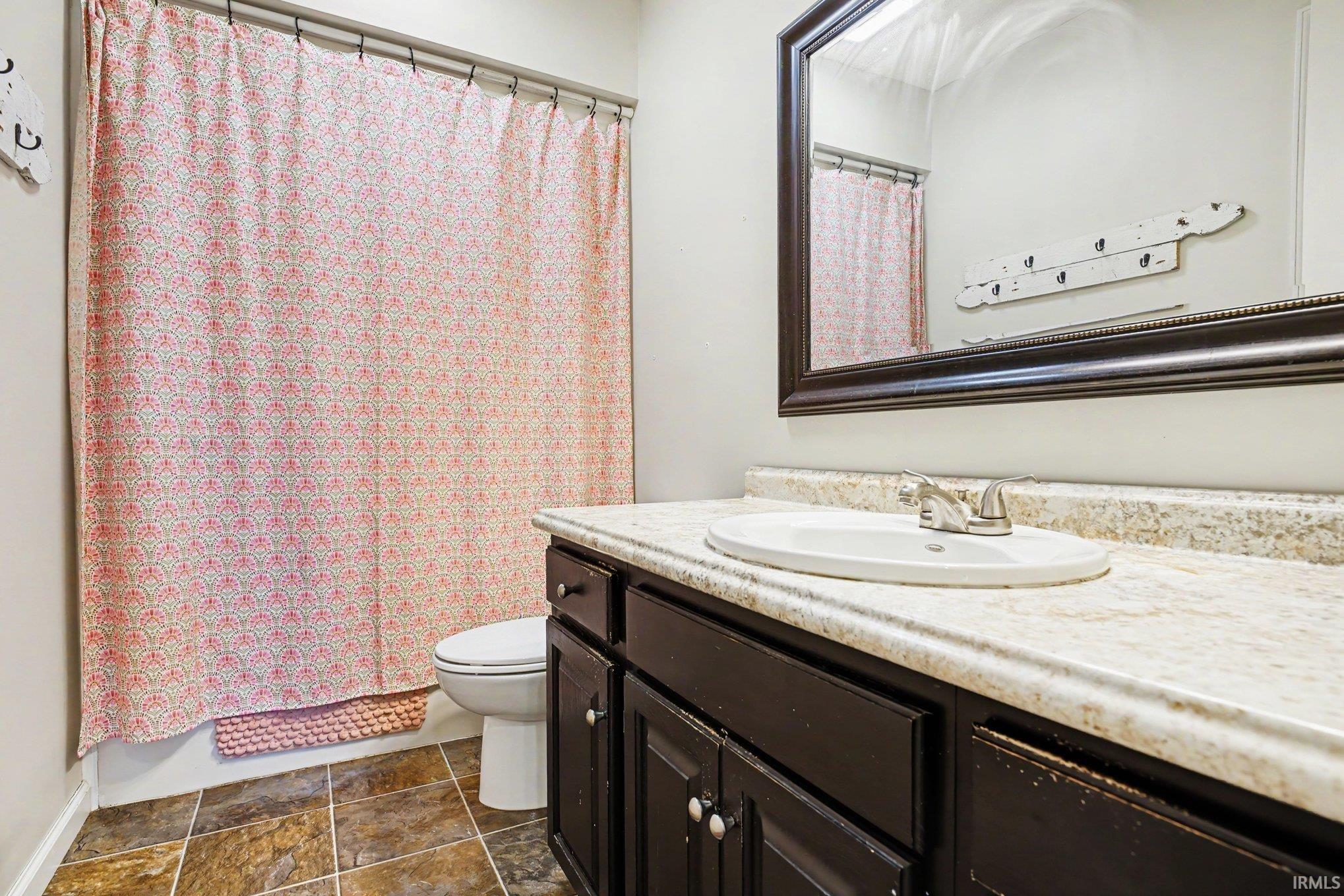 Vanity with a built-in sink, a large framed mirror, and cabinet storage