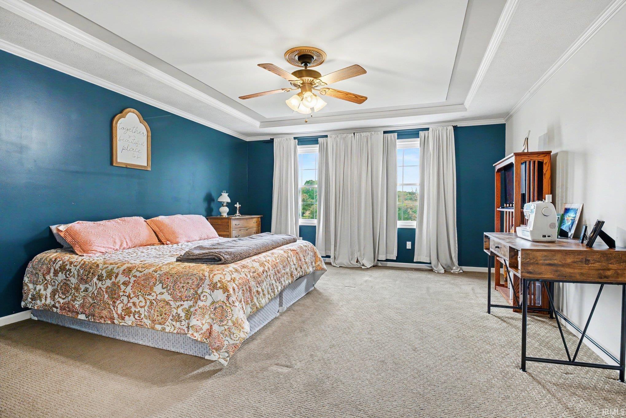 Spacious room with a tray ceiling and ceiling fan light fixture