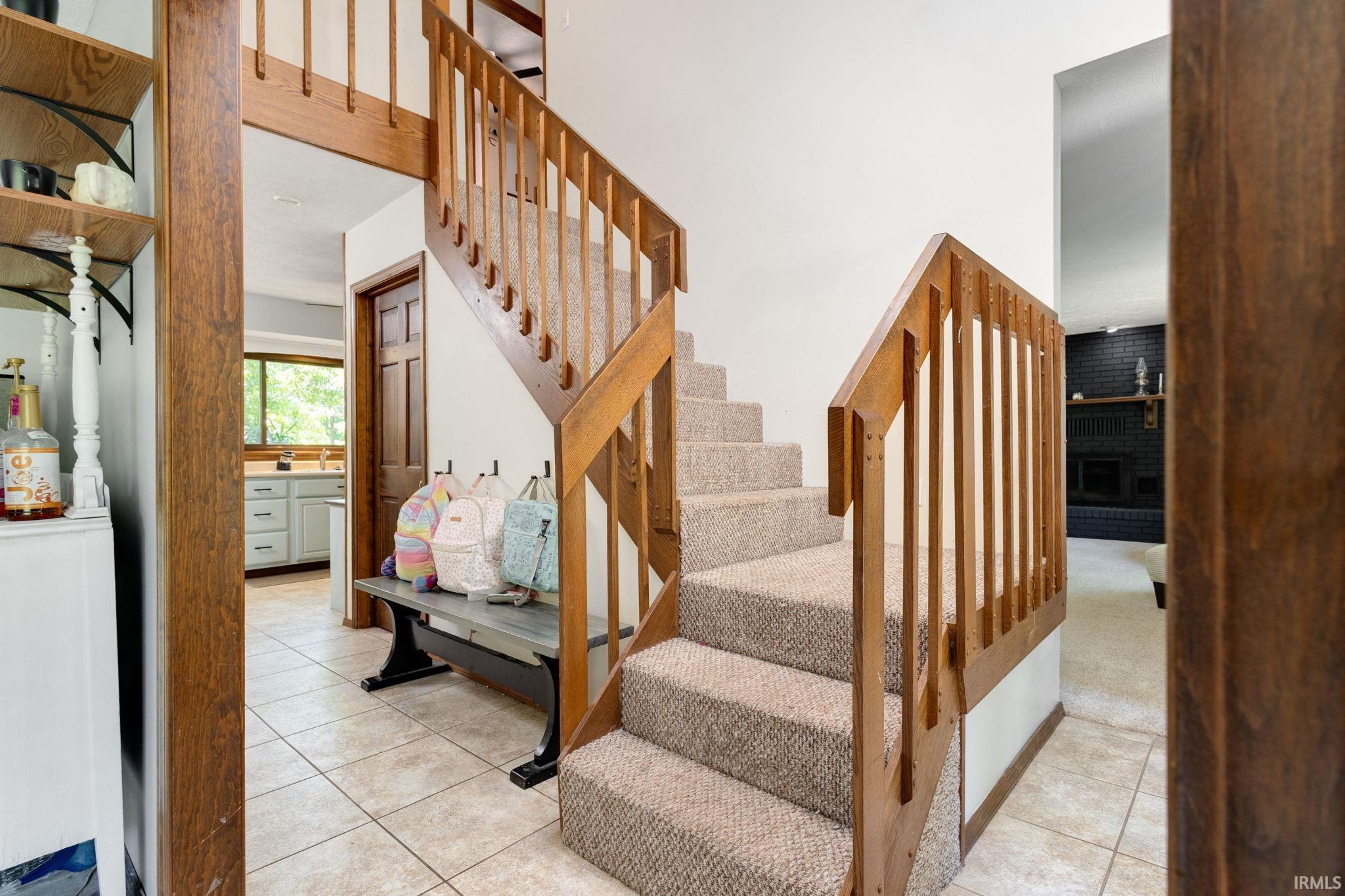 Carpeted staircase with natural wood handrails and balusters