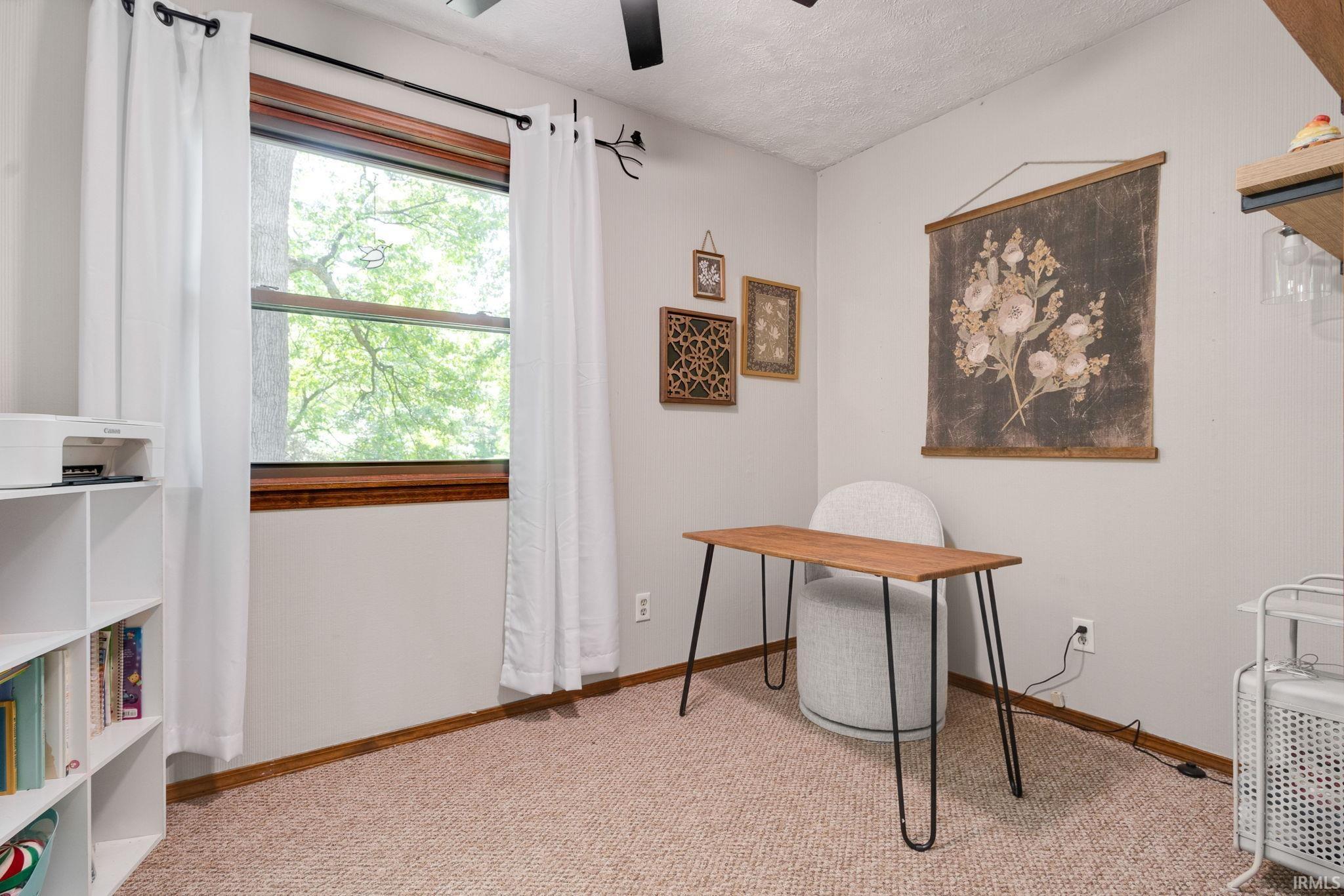 Carpeted room featuring a single window with wood trim, a ceiling fan, and light-colored walls