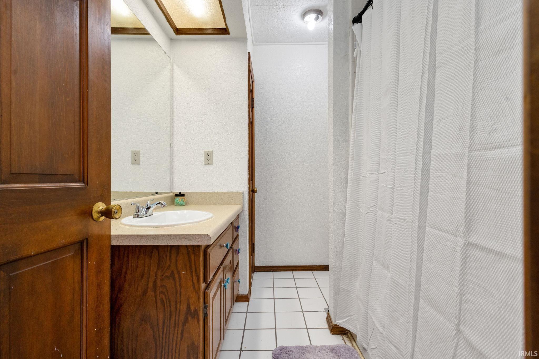 Bathroom vanity with an integrated sink and chrome faucet, set against a full-width mirror