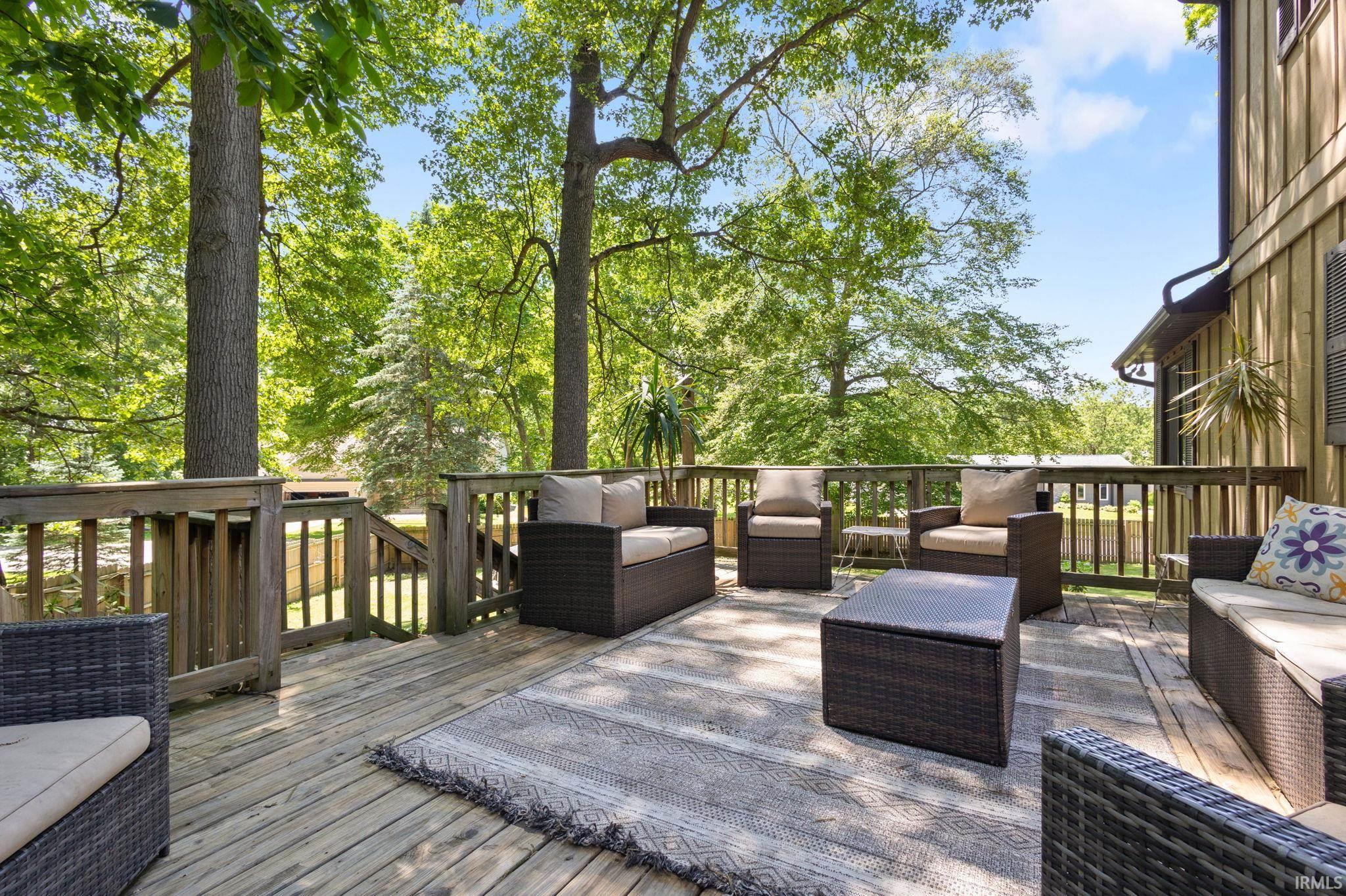 Spacious outdoor deck featuring natural wood decking, sturdy wood railings, and a direct entrance to the property