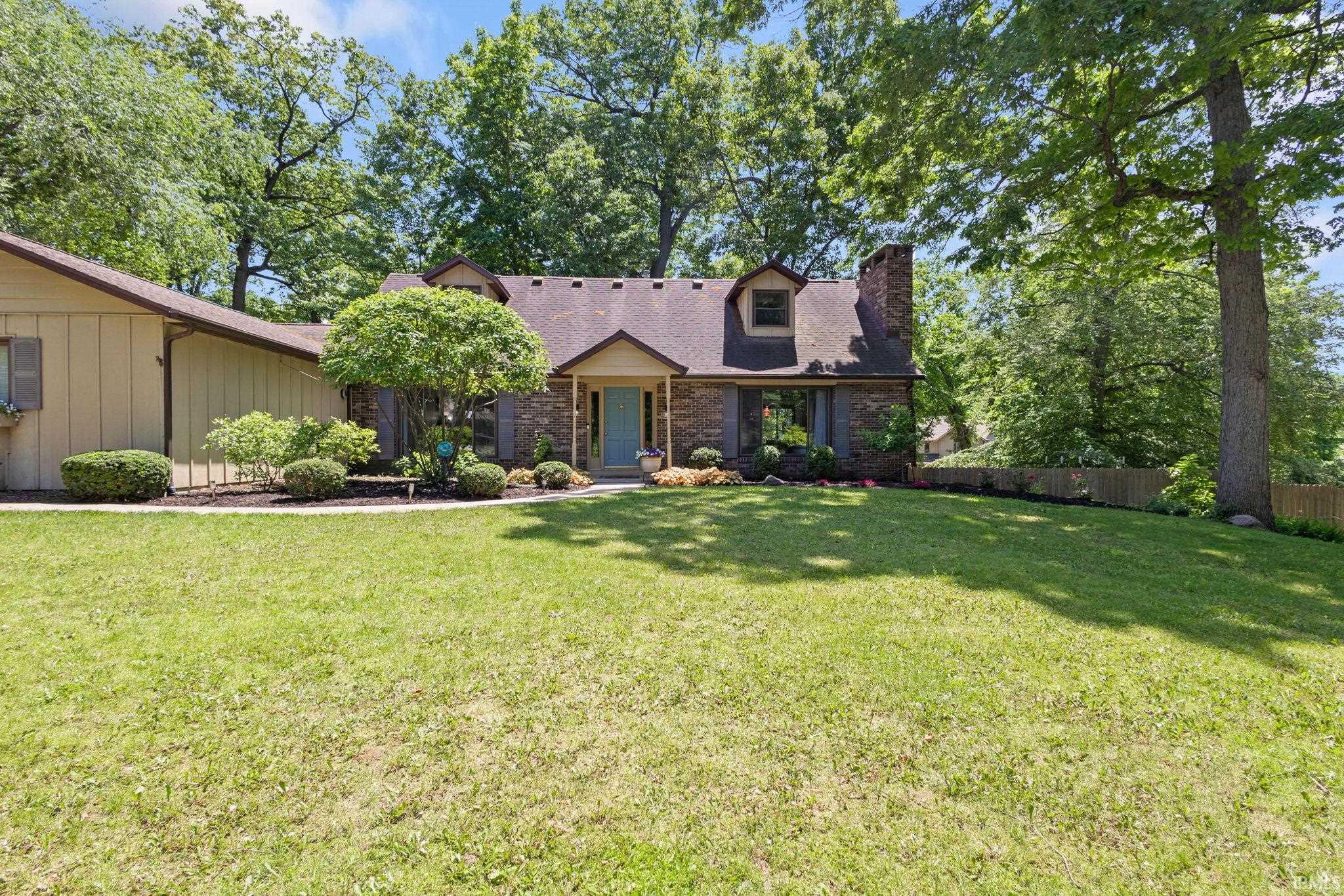 Brick and siding exterior residence featuring a light blue entry door
