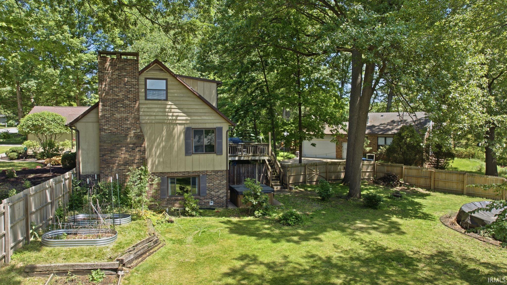 Expansive rear yard featuring mature trees and a manicured lawn