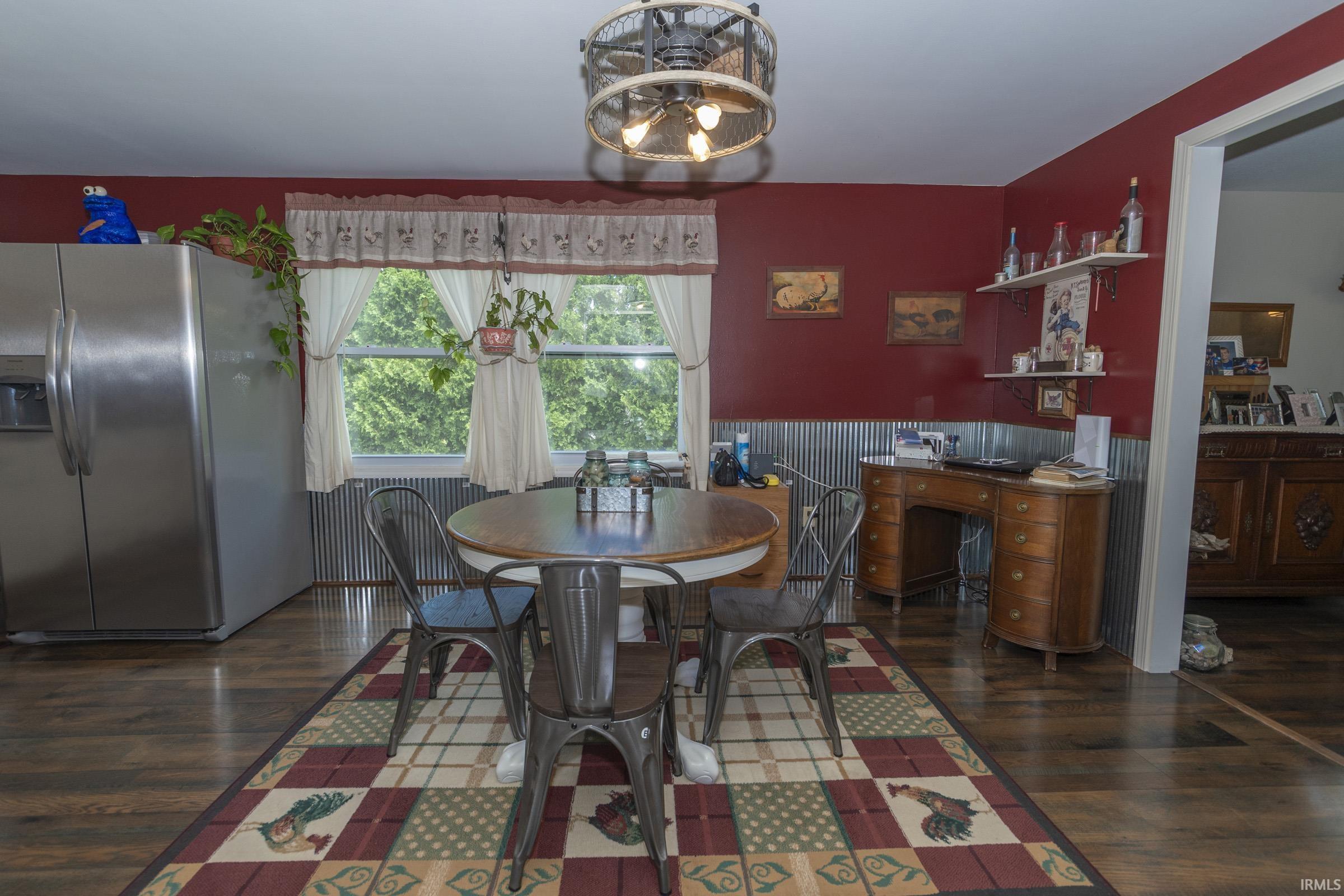 Spacious room featuring wood-finish flooring, a ceiling fan with integrated lighting, and a window offering abundant natural light