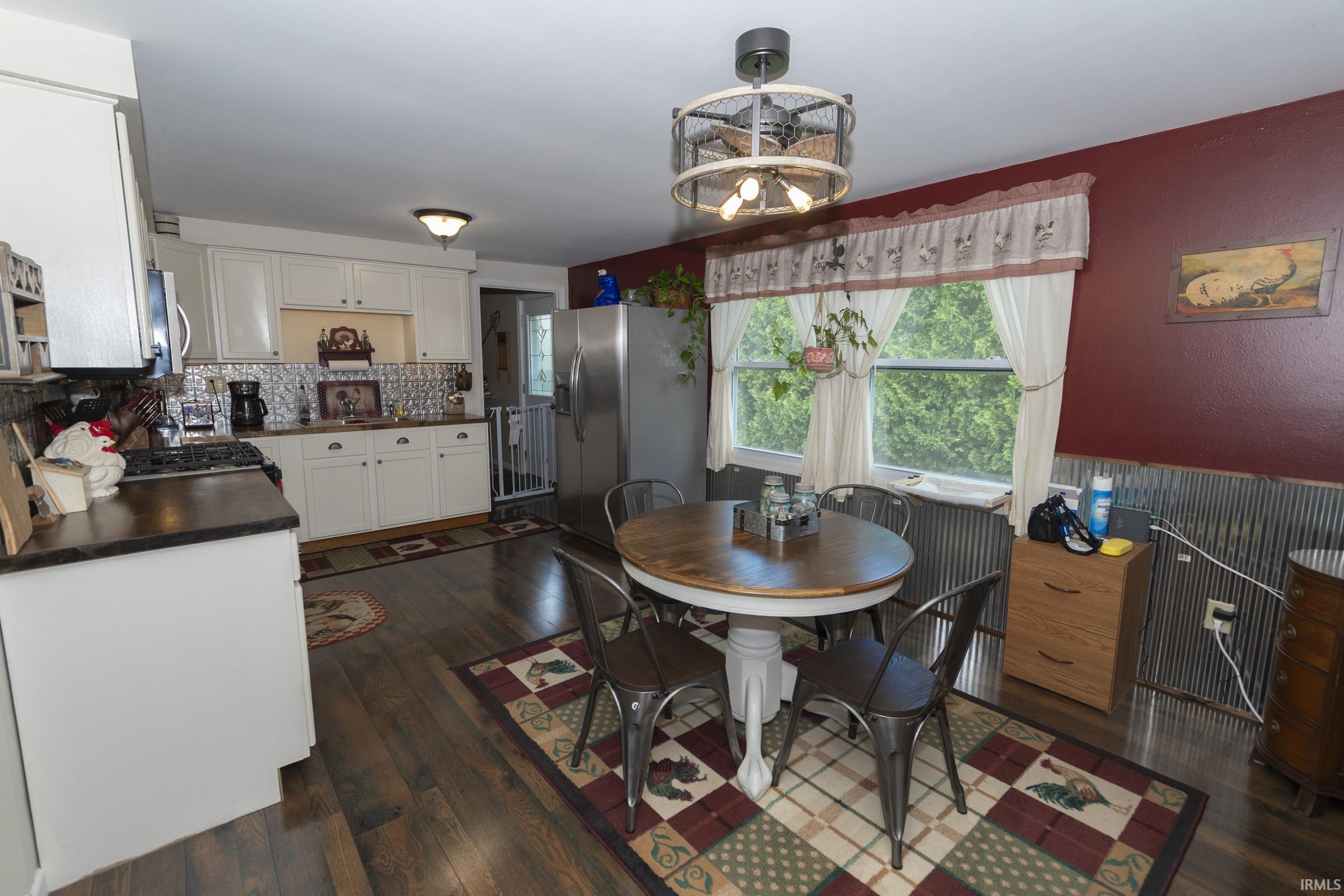 Kitchen featuring wood-finish flooring, white cabinetry, and a decorative tile backsplash