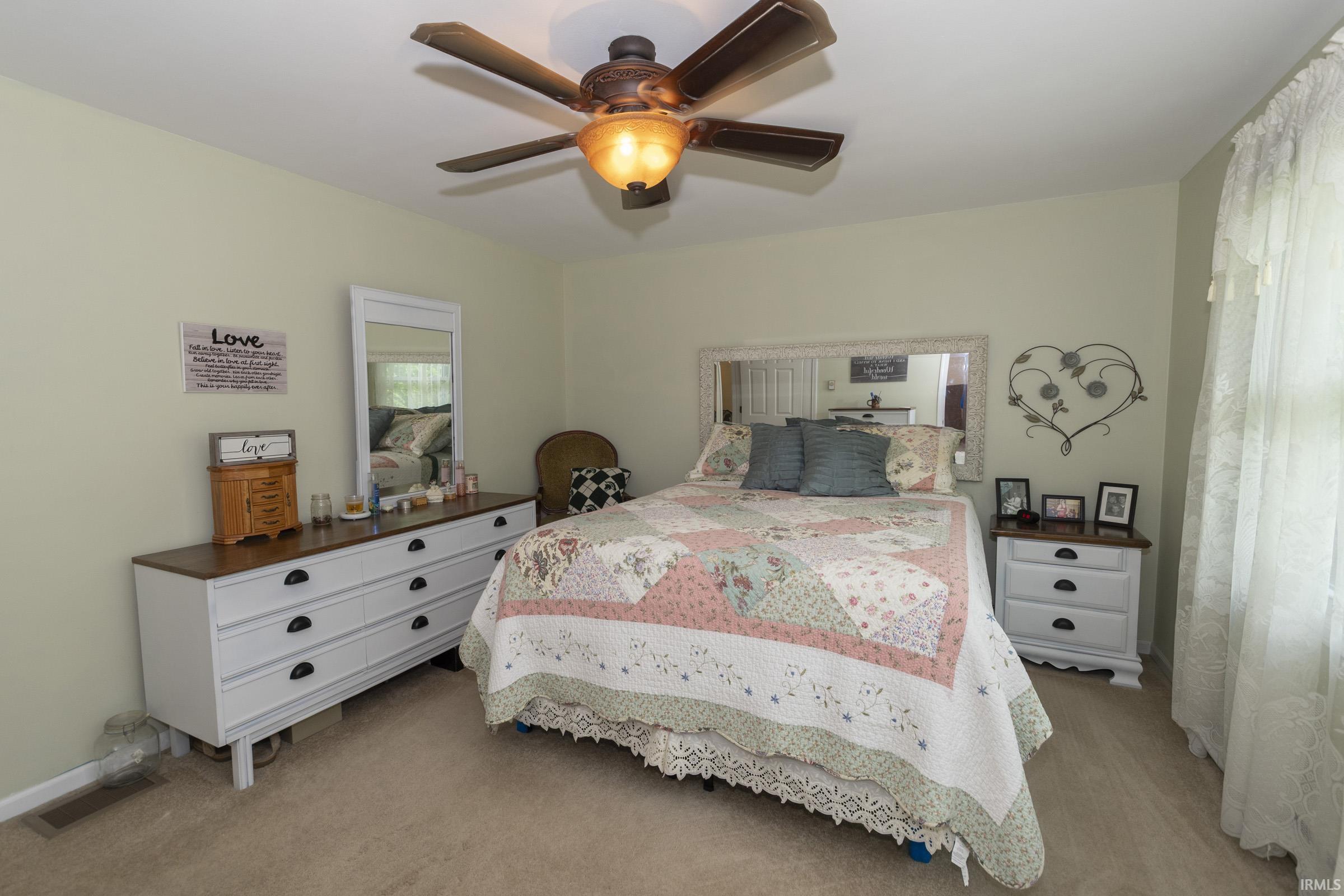 Carpeted room featuring light-colored walls and a ceiling fan with integrated lighting