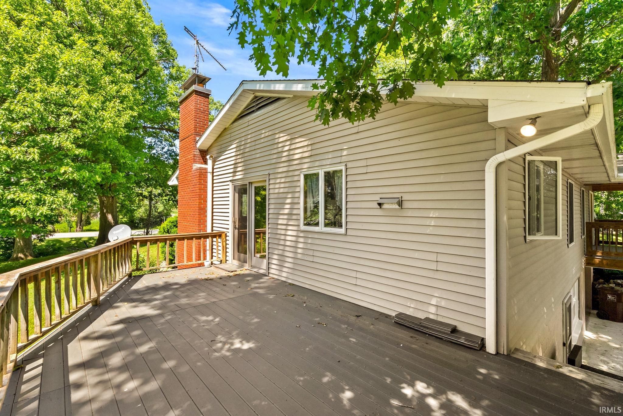 Spacious outdoor deck with composite decking and wood railing, providing an open-air extension of the living space