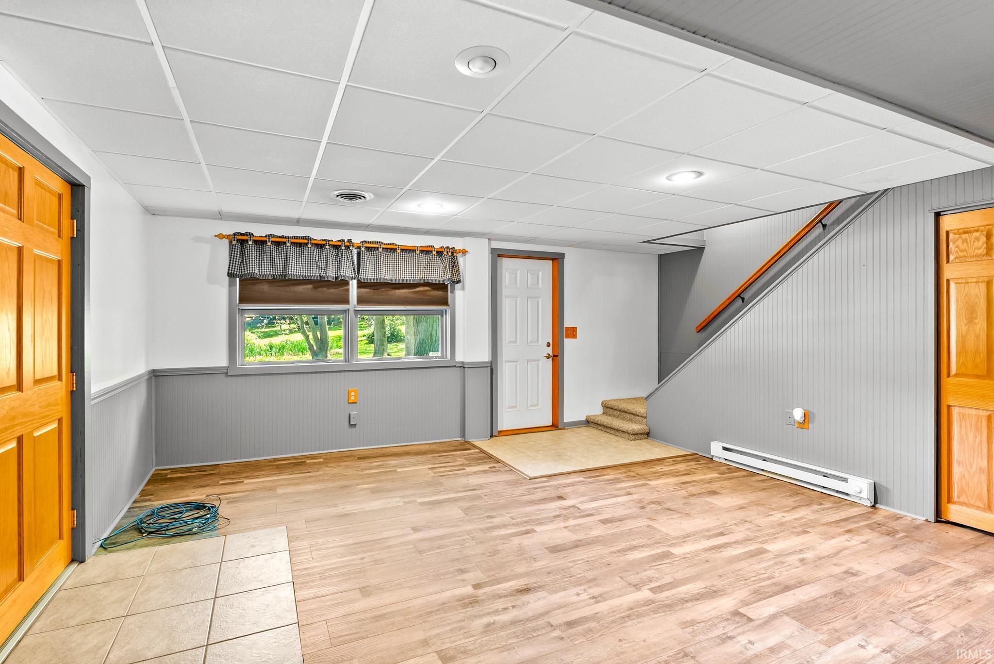 Finished lower level featuring wood-finish flooring, recessed lighting, and a drop ceiling