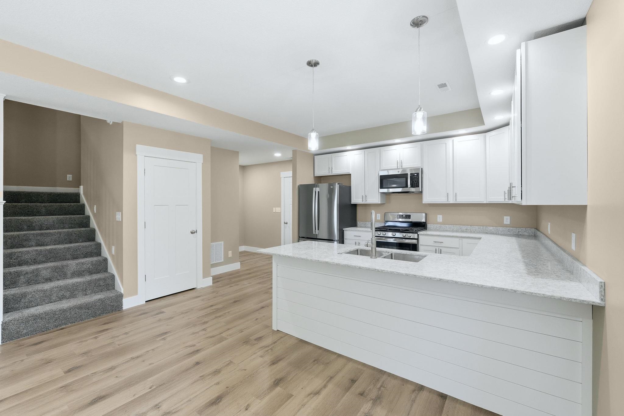 Full kitchen featuring white cabinetry, stainless steel appliances, and light-toned countertops
