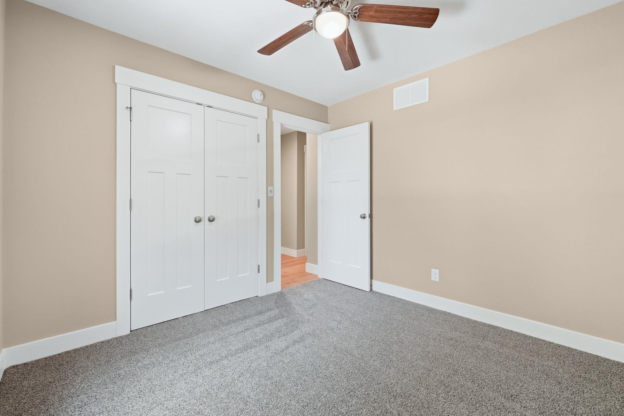 Room featuring gray carpet flooring, beige painted walls, and white trim