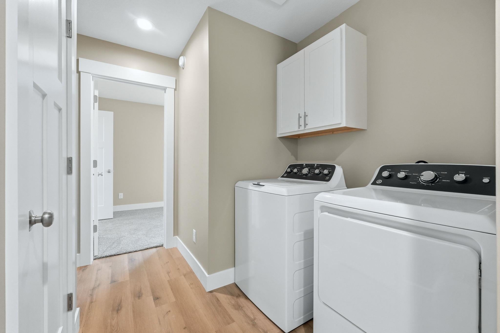 Dedicated laundry area featuring wood-finish flooring and neutral wall tones
