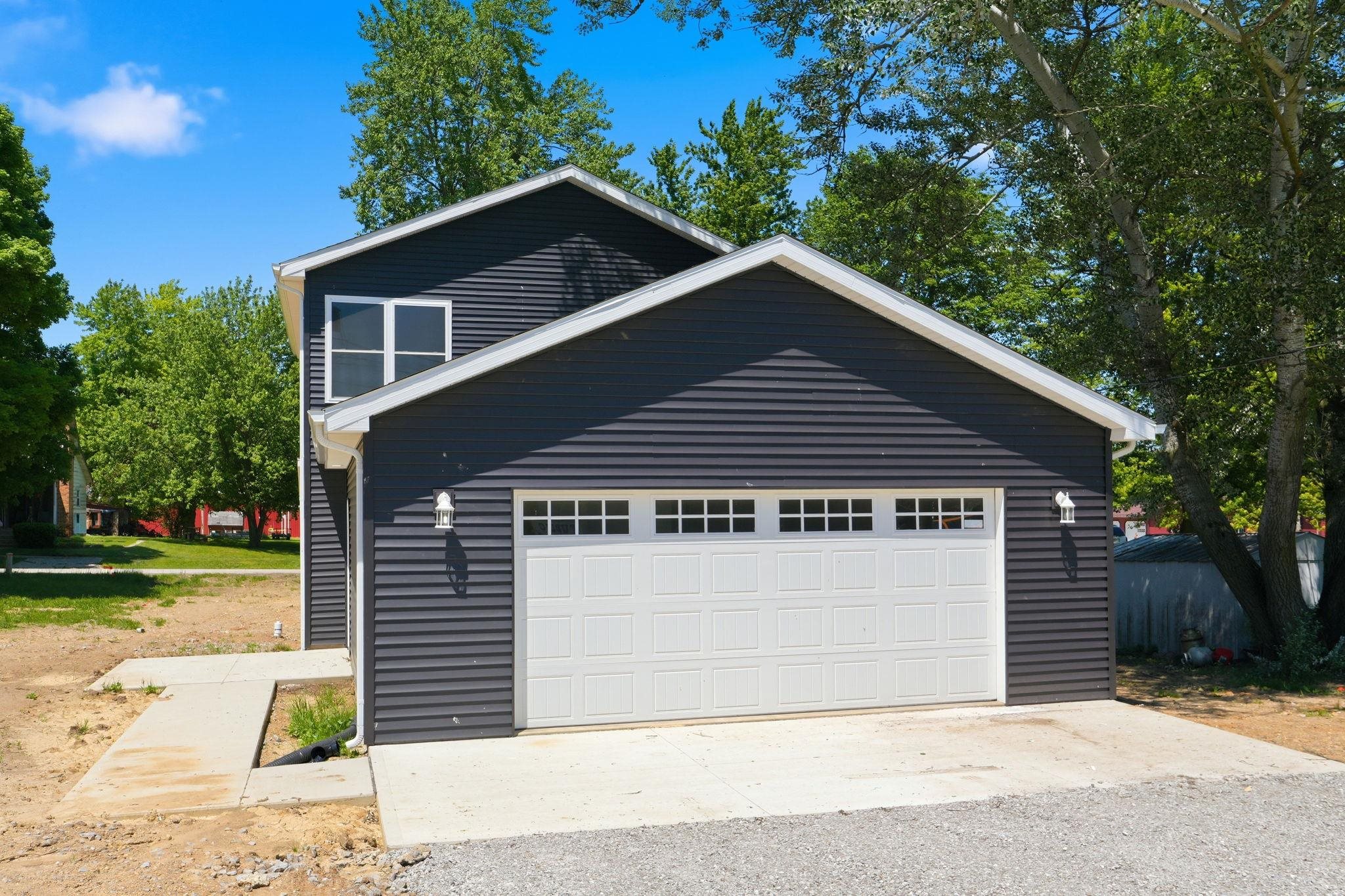 Two-story structure with dark horizontal siding and white trim