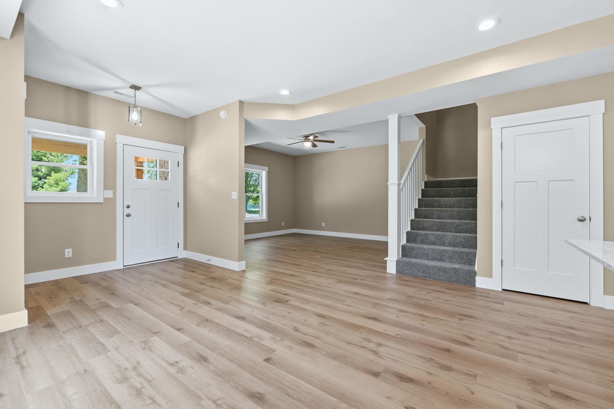 Expansive open-concept living area featuring wood-finish flooring, recessed lighting, and a neutral color palette