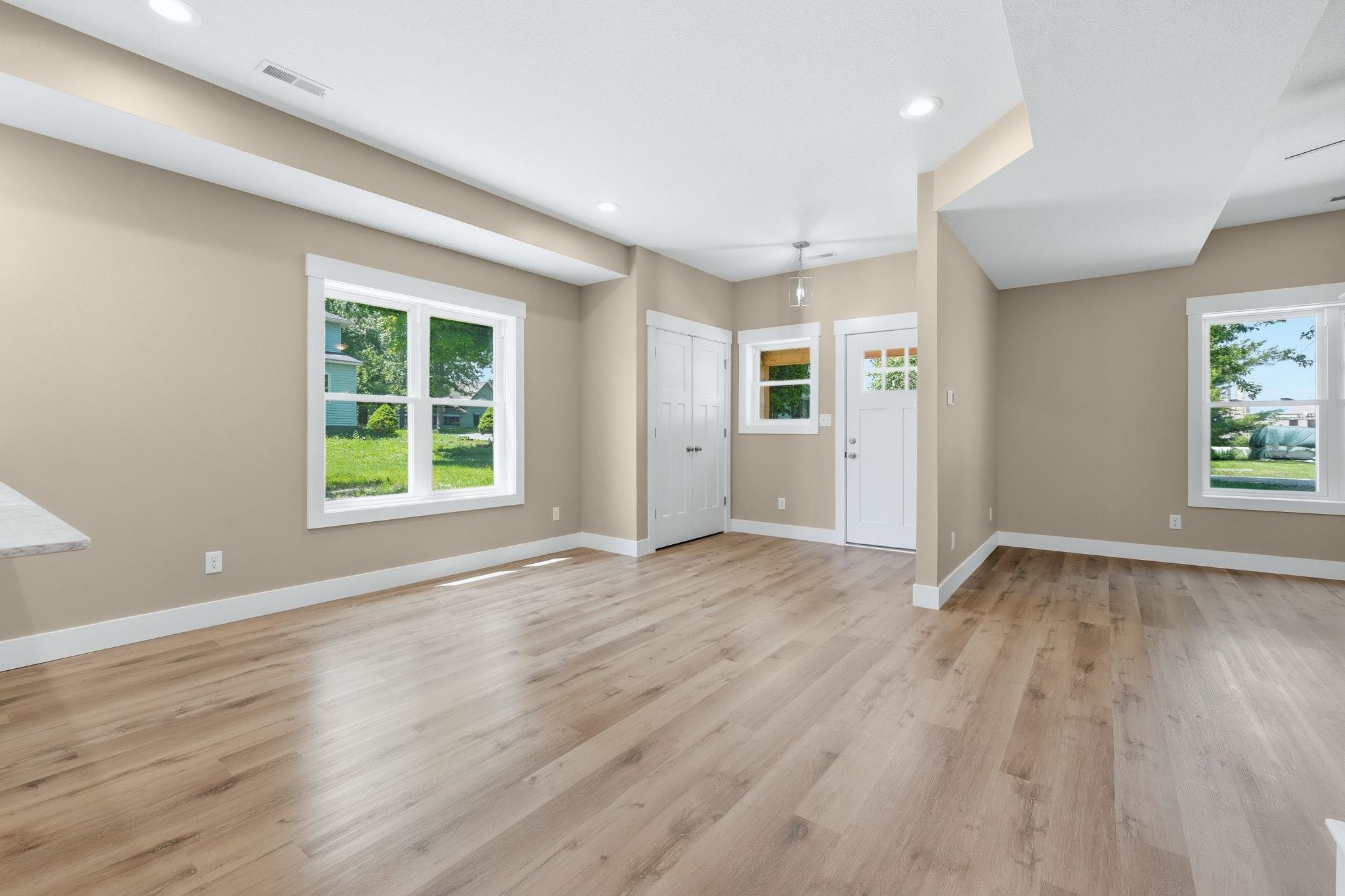 Expansive open-concept room featuring light wood-finish flooring and recessed lighting
