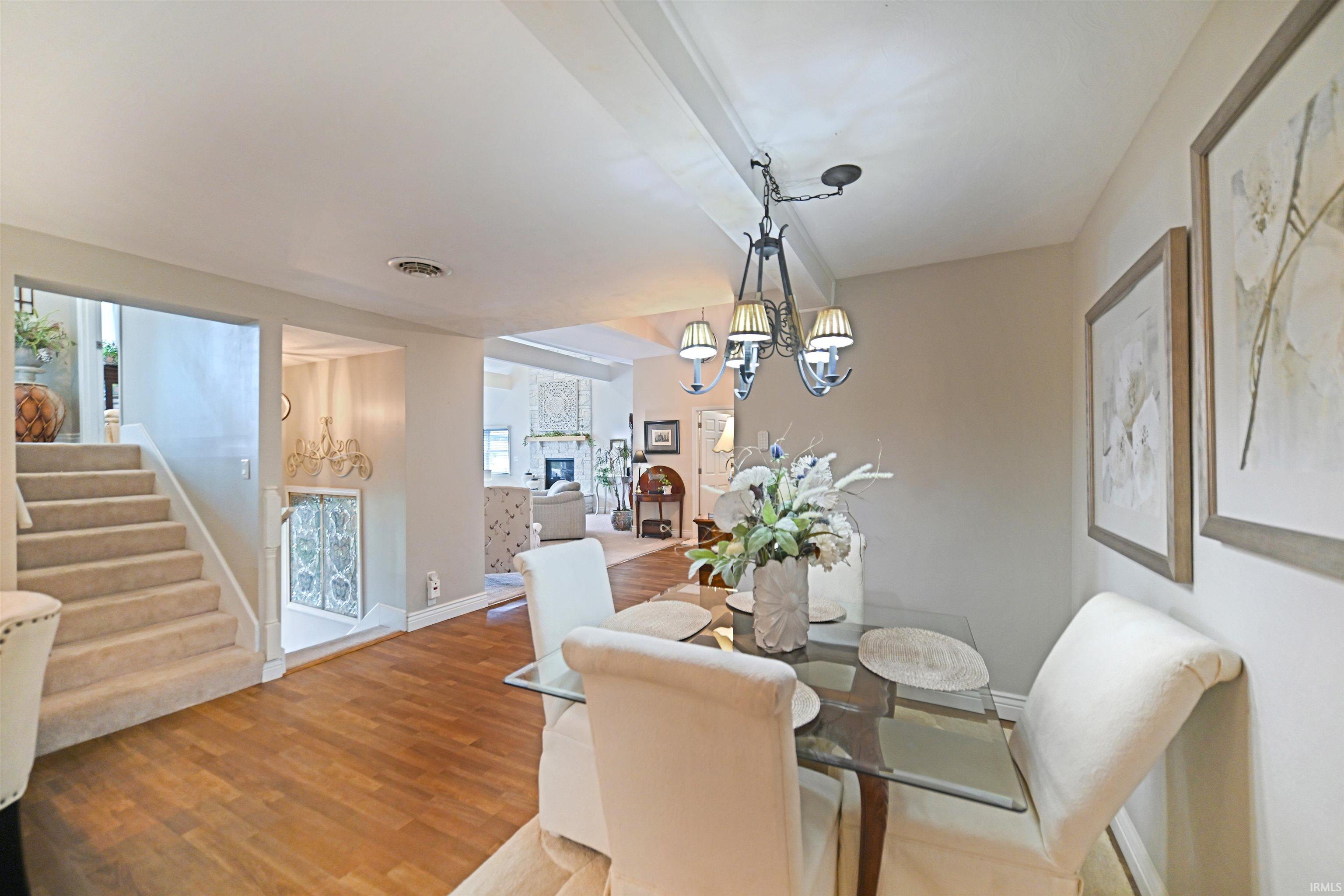Dining area featuring wood-finish flooring, a decorative chandelier, and framed wall art