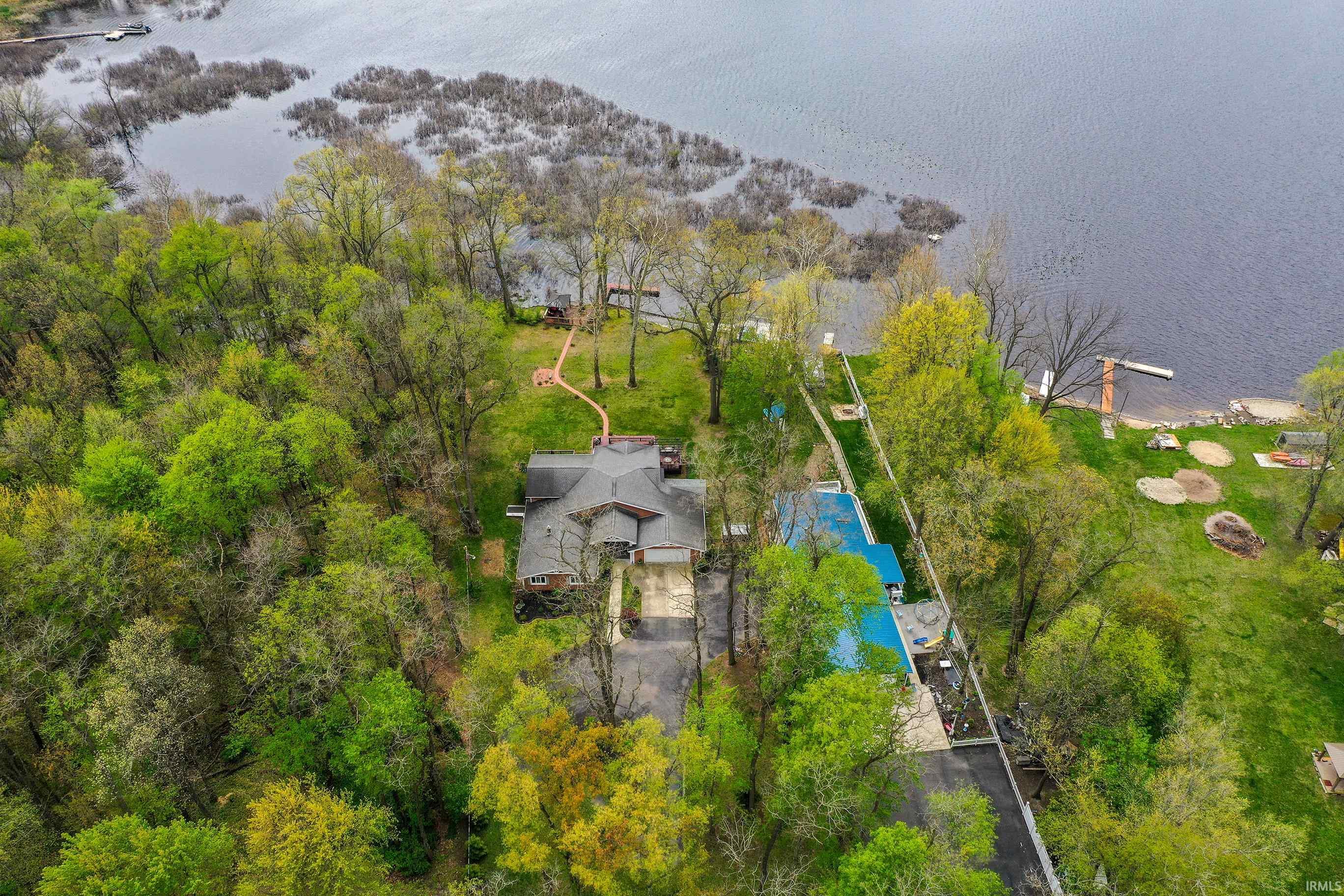 Expansive waterfront property featuring a multi-level residence, private boat dock, and lush surrounding foliage