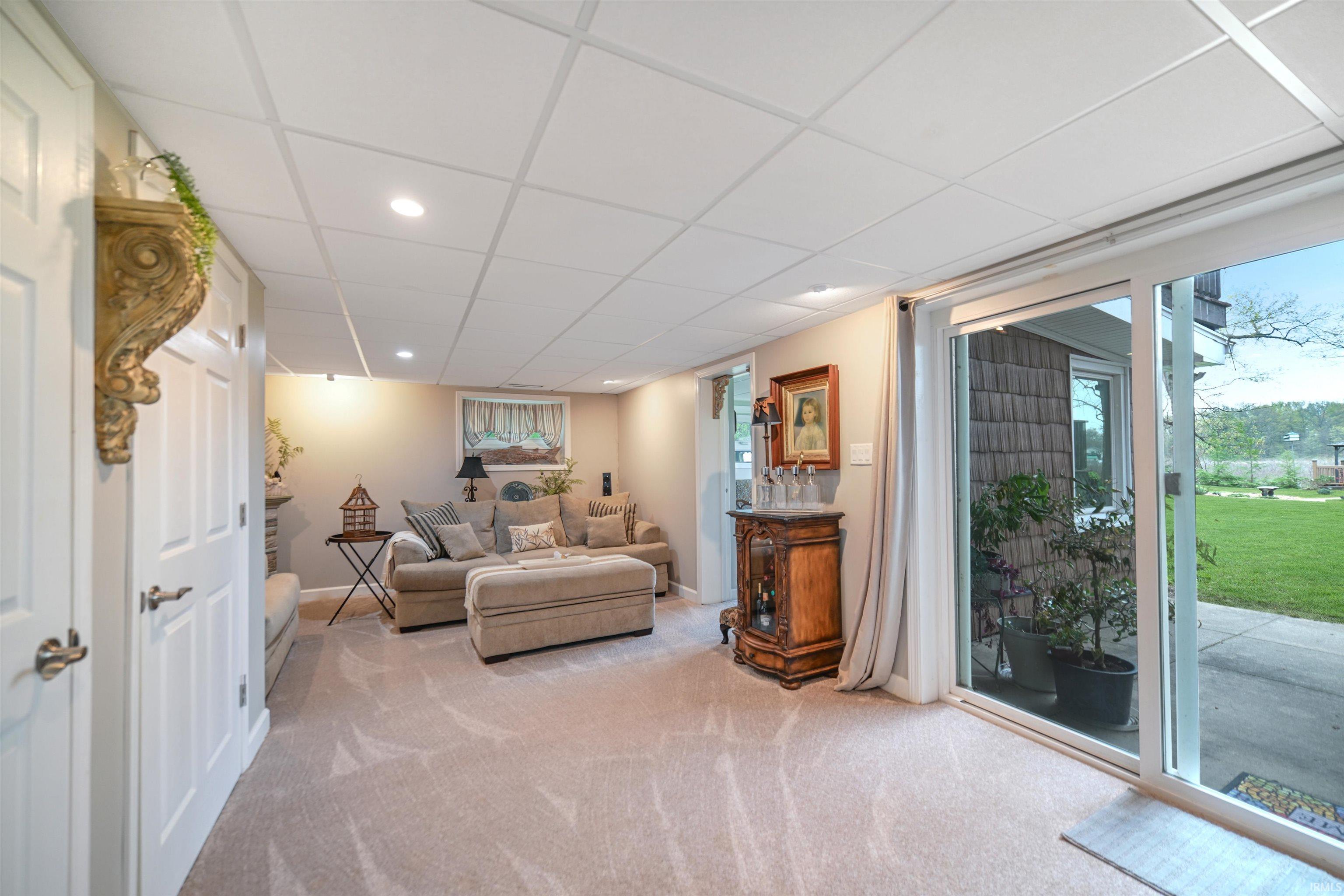 Carpeted living space featuring recessed lighting and a drop ceiling