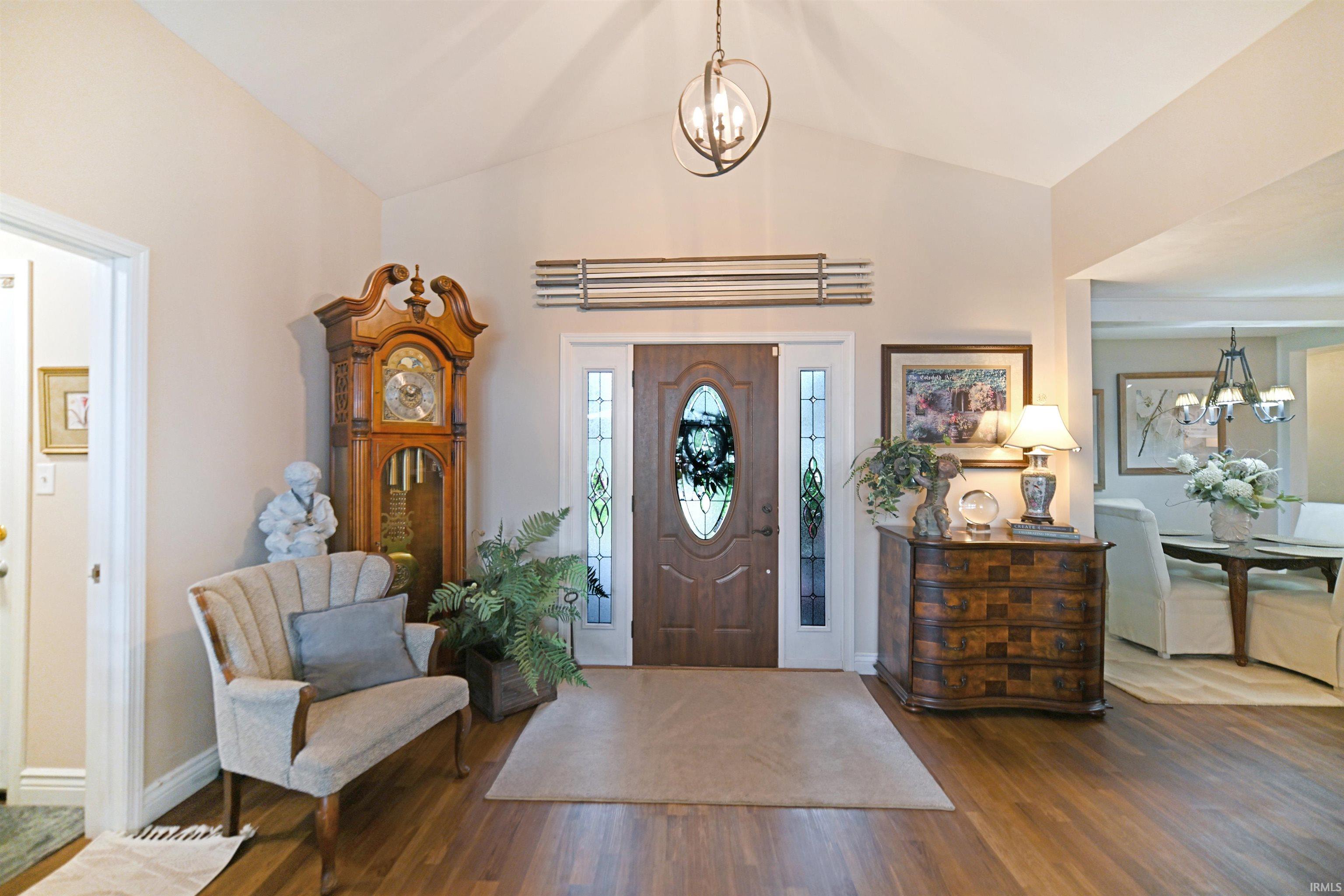 Grand entryway featuring a vaulted ceiling and wood-finish flooring