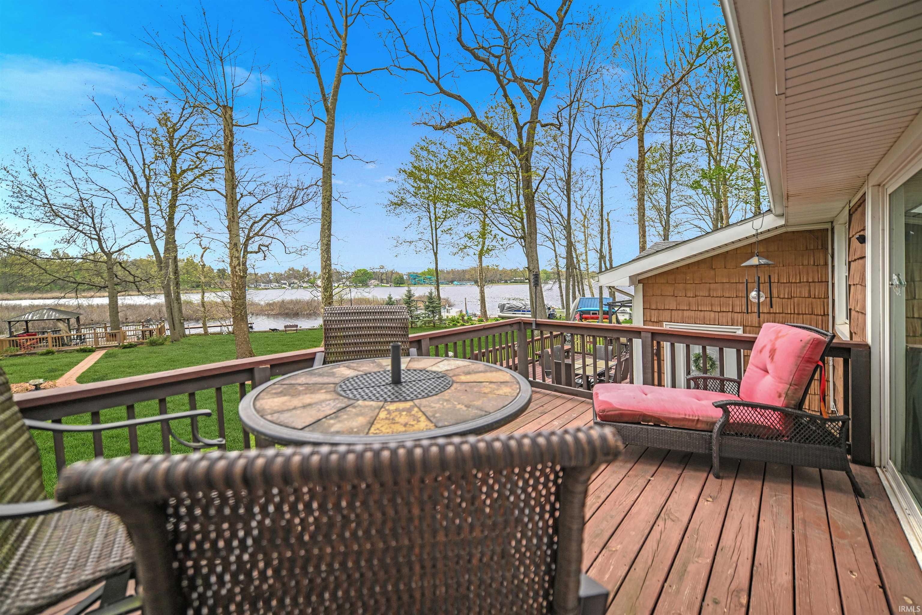 Expansive wood-finish deck with dark railings, offering waterfront exposure
