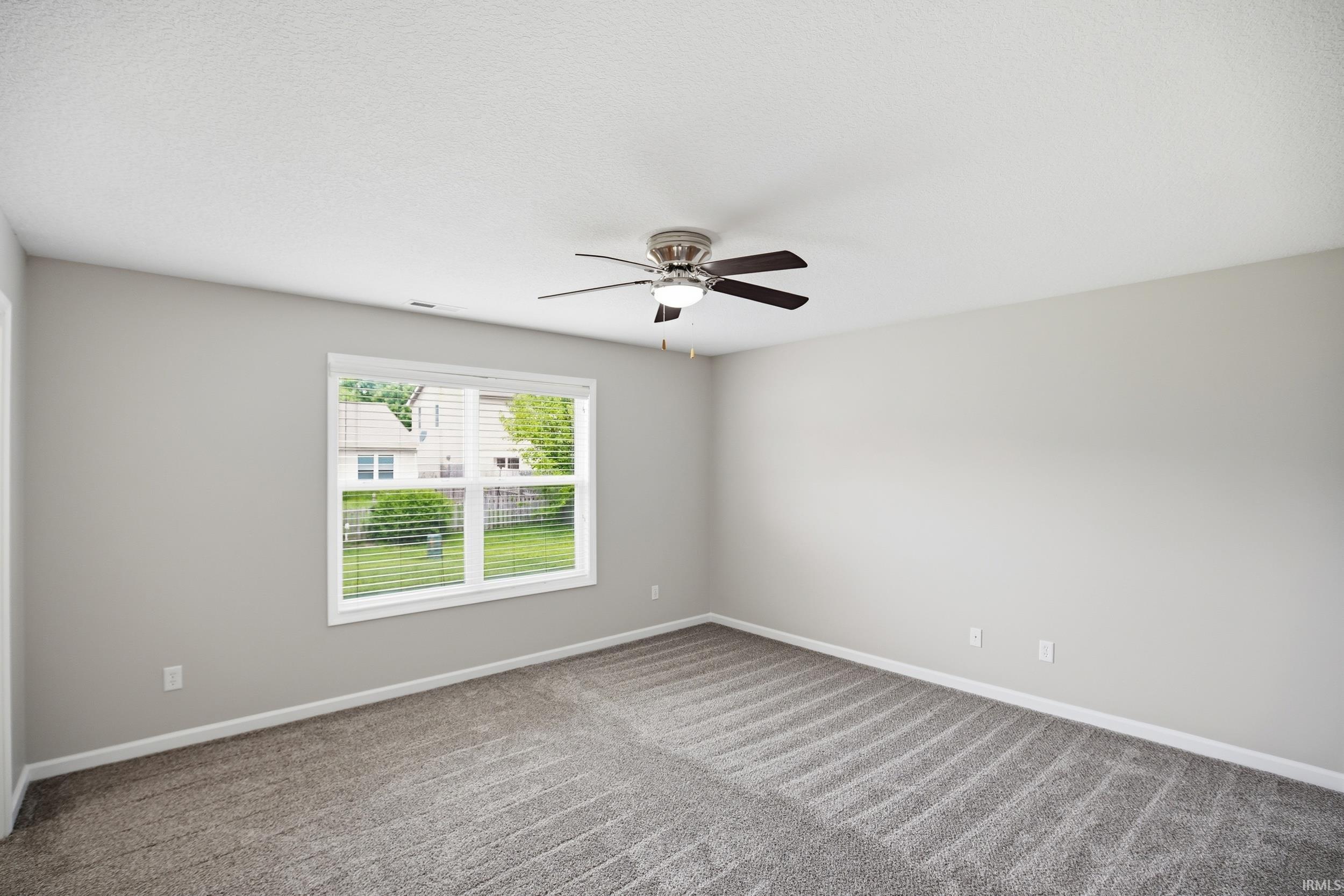 Spacious room featuring neutral grey walls and a white ceiling with a contemporary ceiling fan