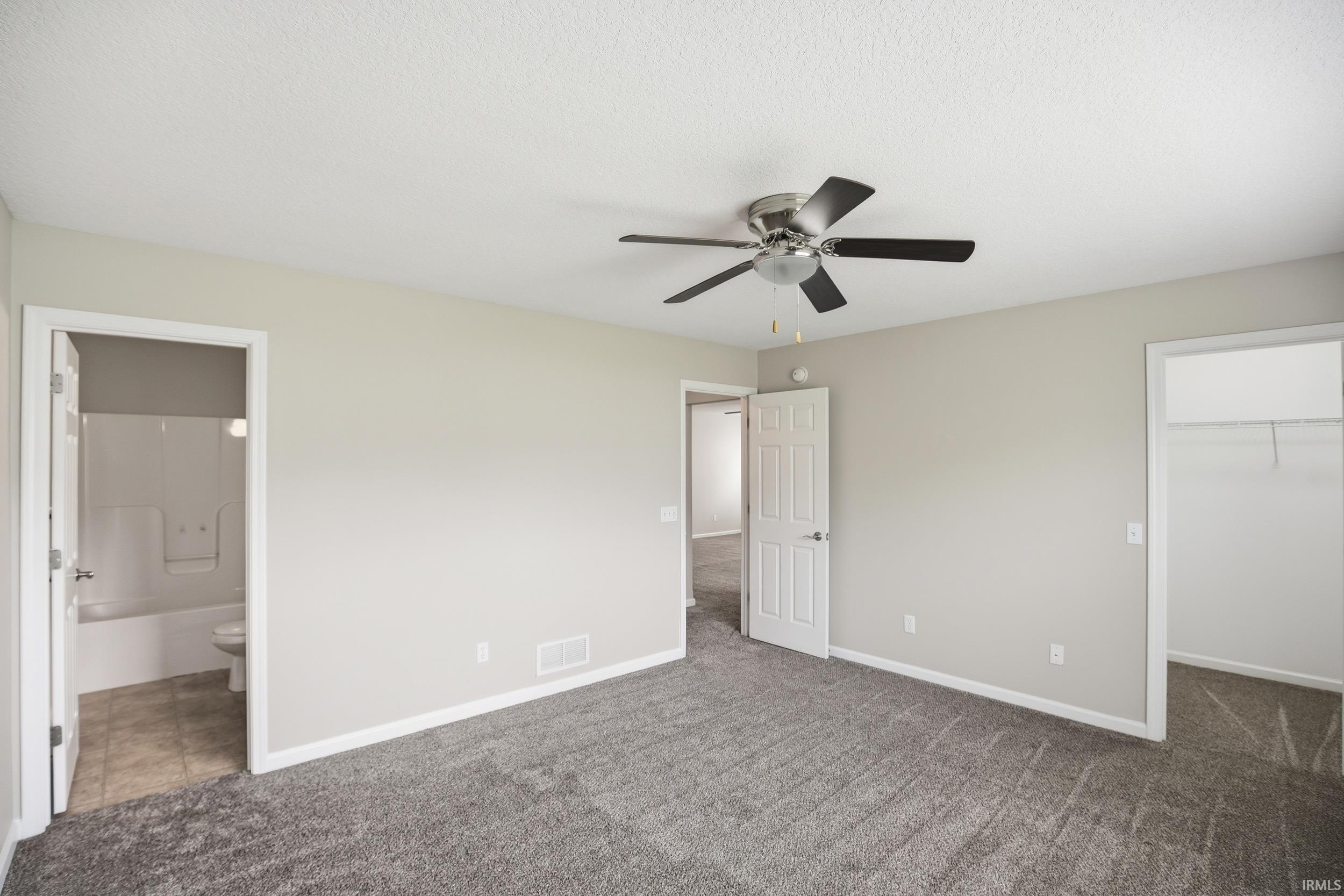 Spacious room with gray carpet, neutral wall color, and a ceiling fan