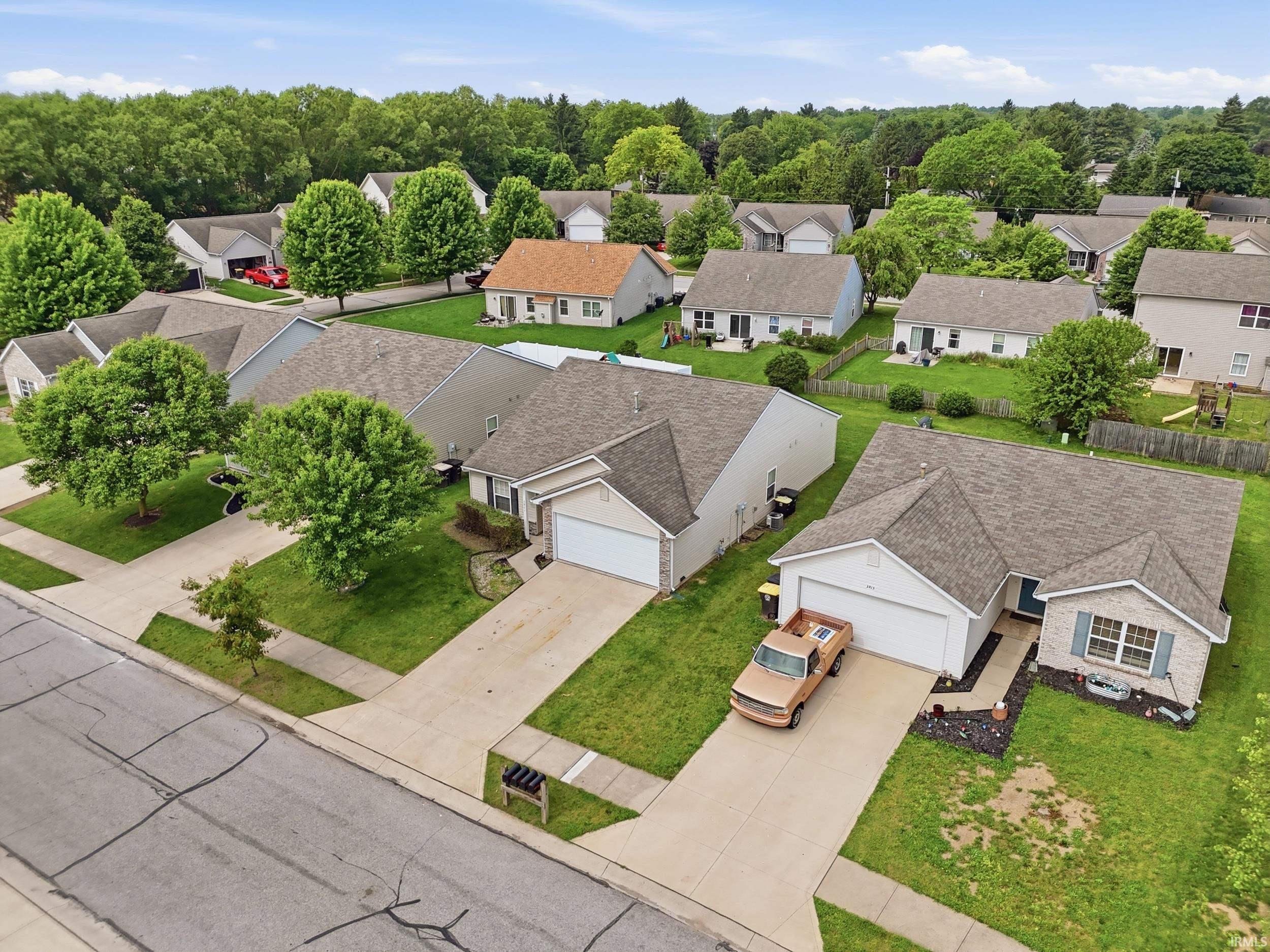 Residential neighborhood with mature trees, established landscaping, and paved streets