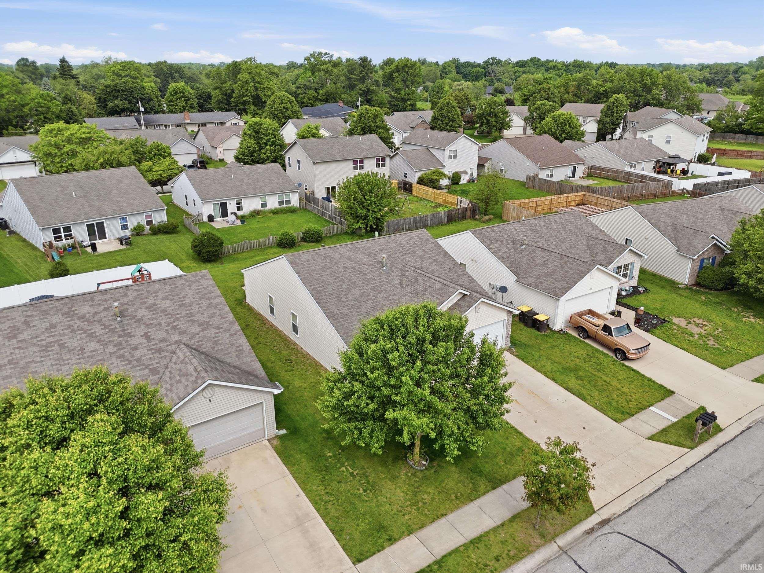 Residential neighborhood featuring multiple single-story and two-story homes with attached garages, shingle roofs, and light-colored siding