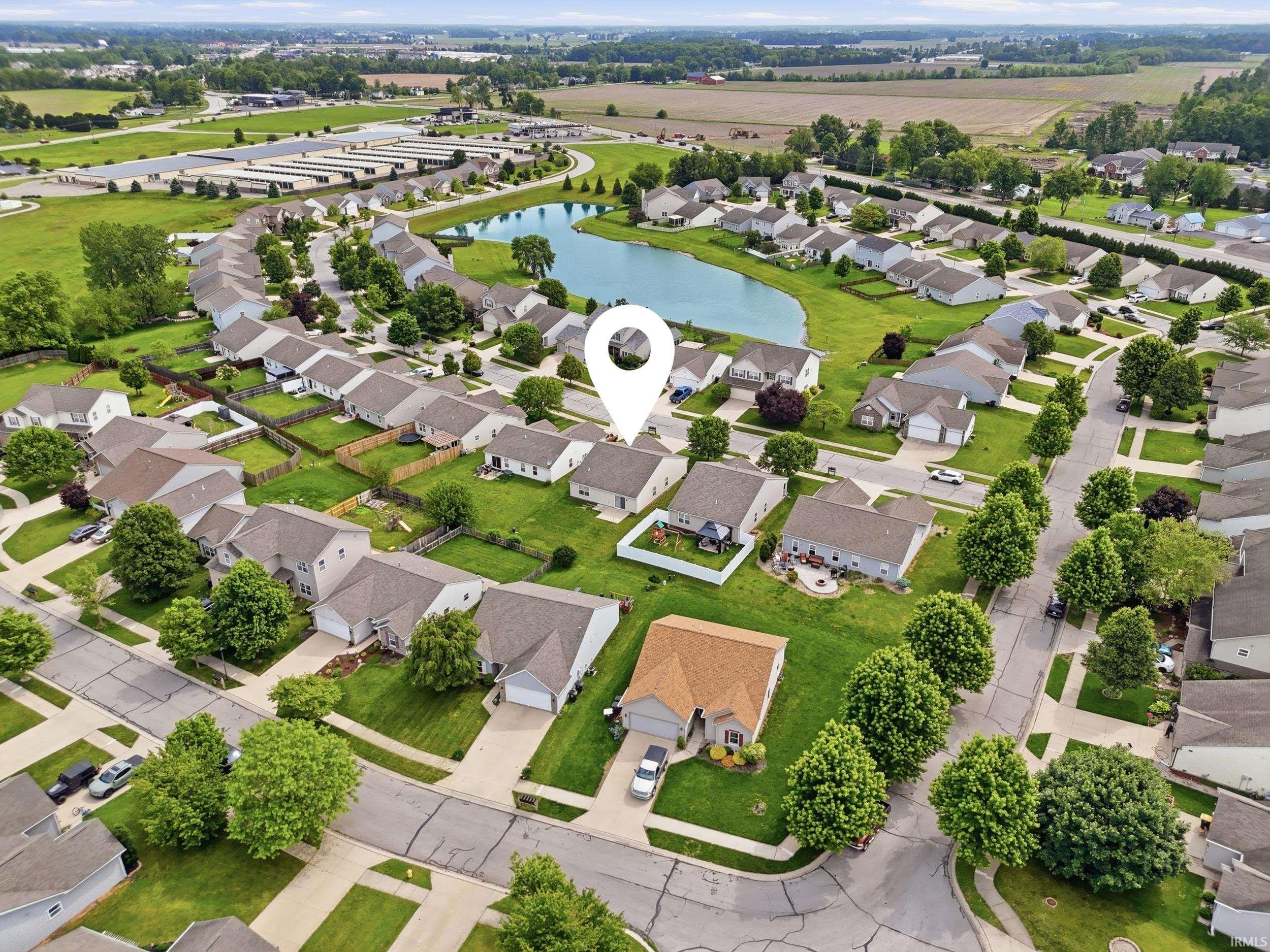 Aerial view of a residential neighborhood with a central pond