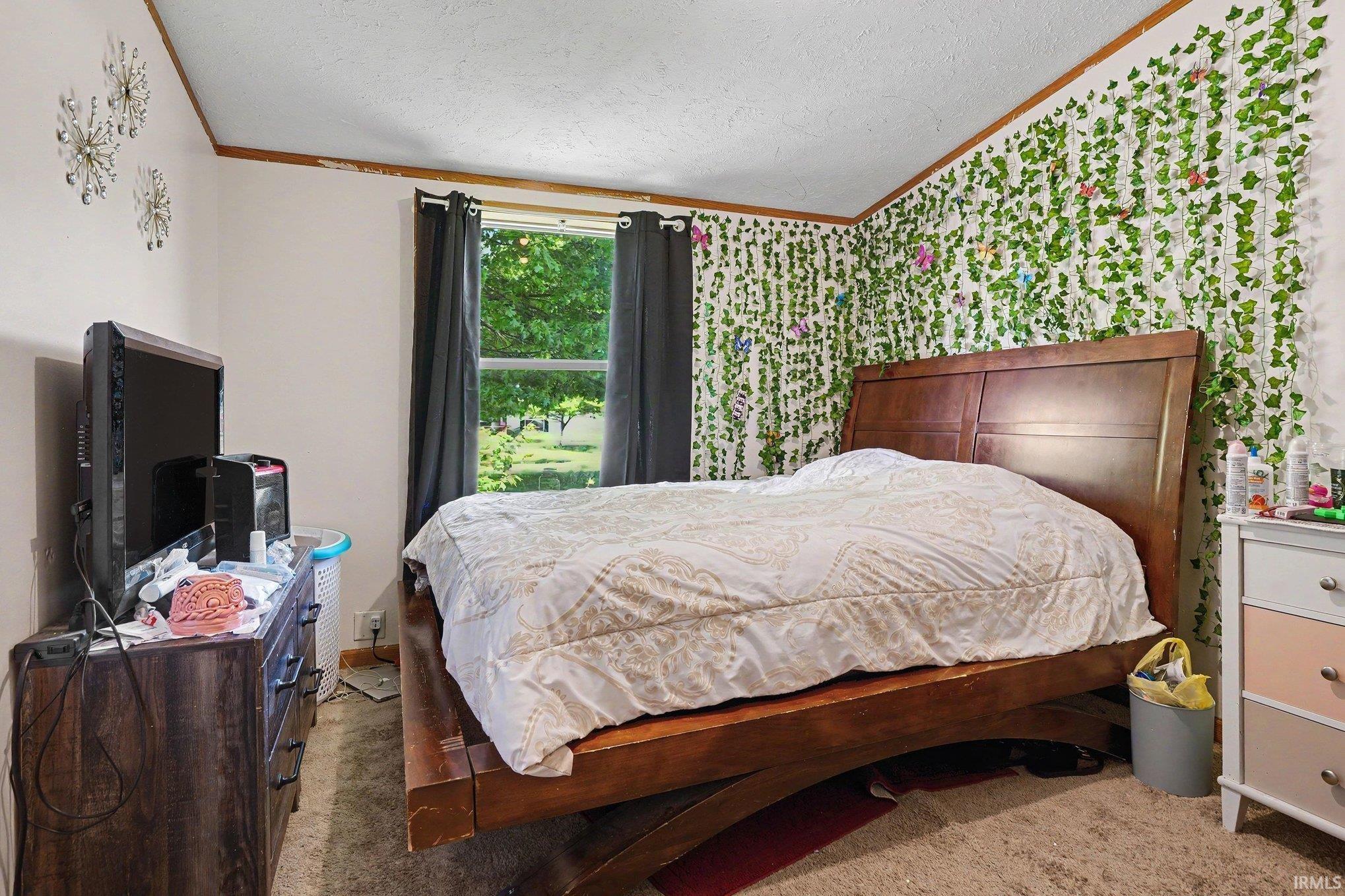 Room featuring a window with dark curtains, a textured ceiling, and wood trim