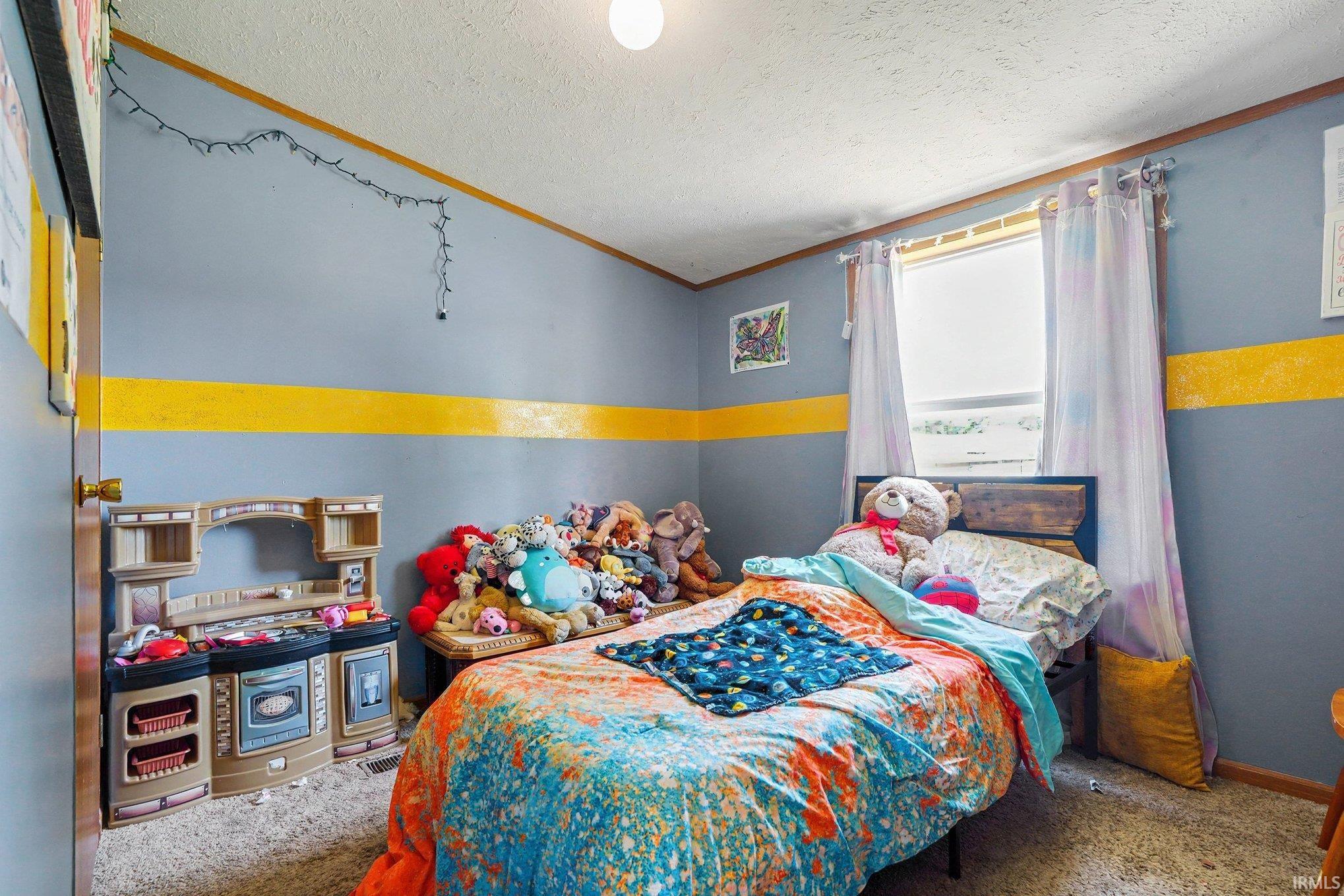 Bedroom featuring a single window with blinds, carpeted flooring, and a door with a brass-finish knob
