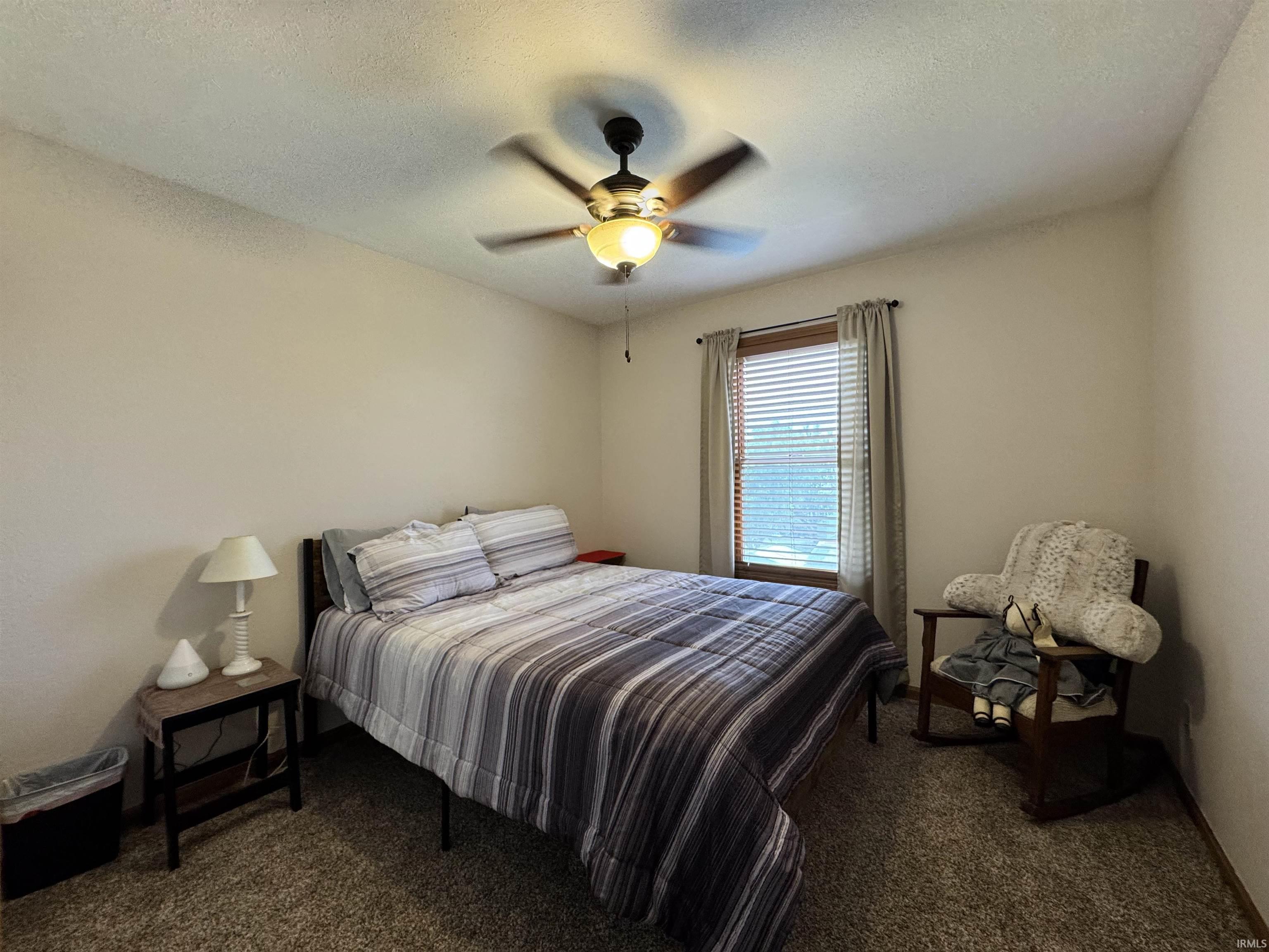 Neutral wall paint in a well-lit room featuring a window with blinds and drapes