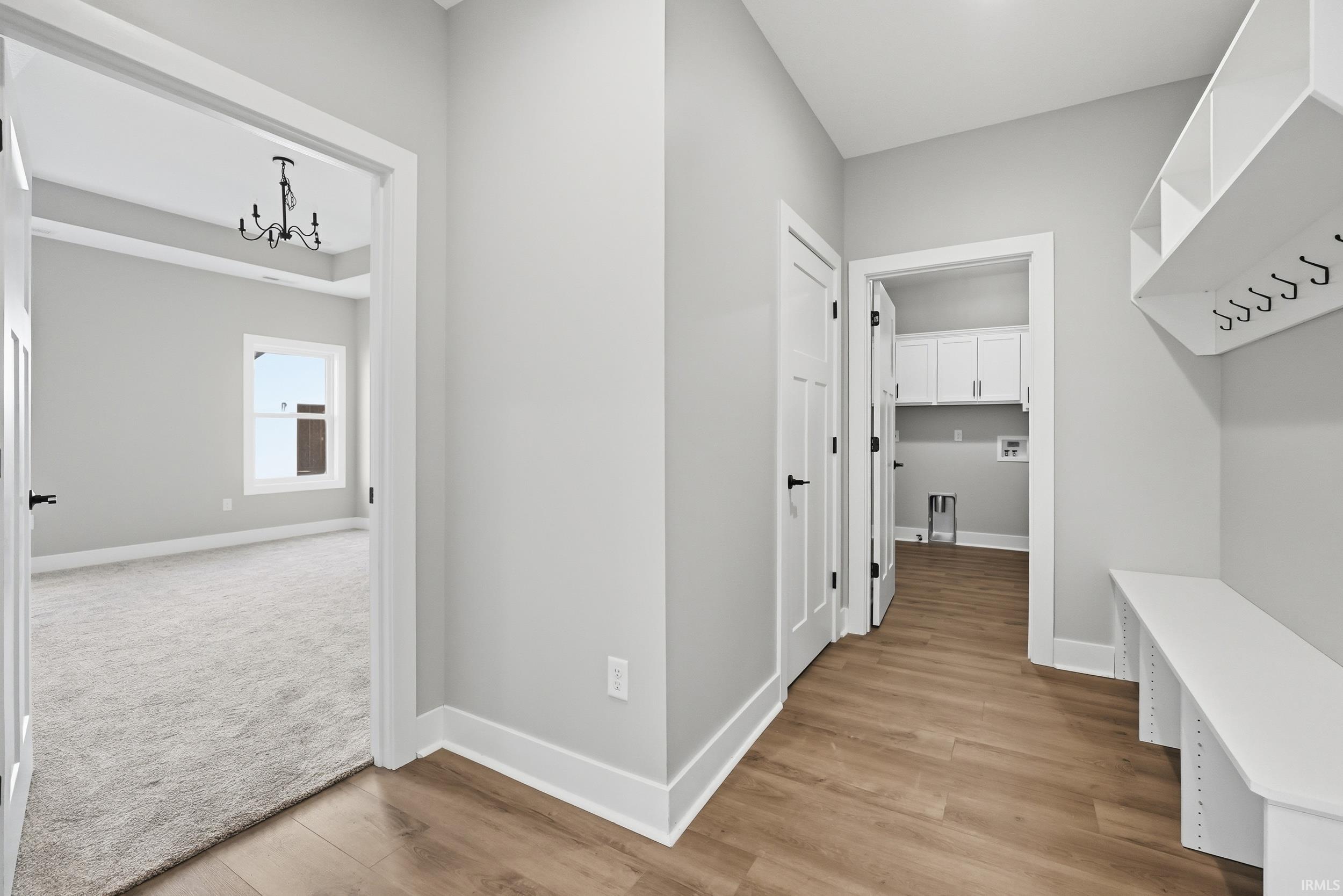 Entry area featuring wood-finish flooring, built-in bench with storage, and coat hooks