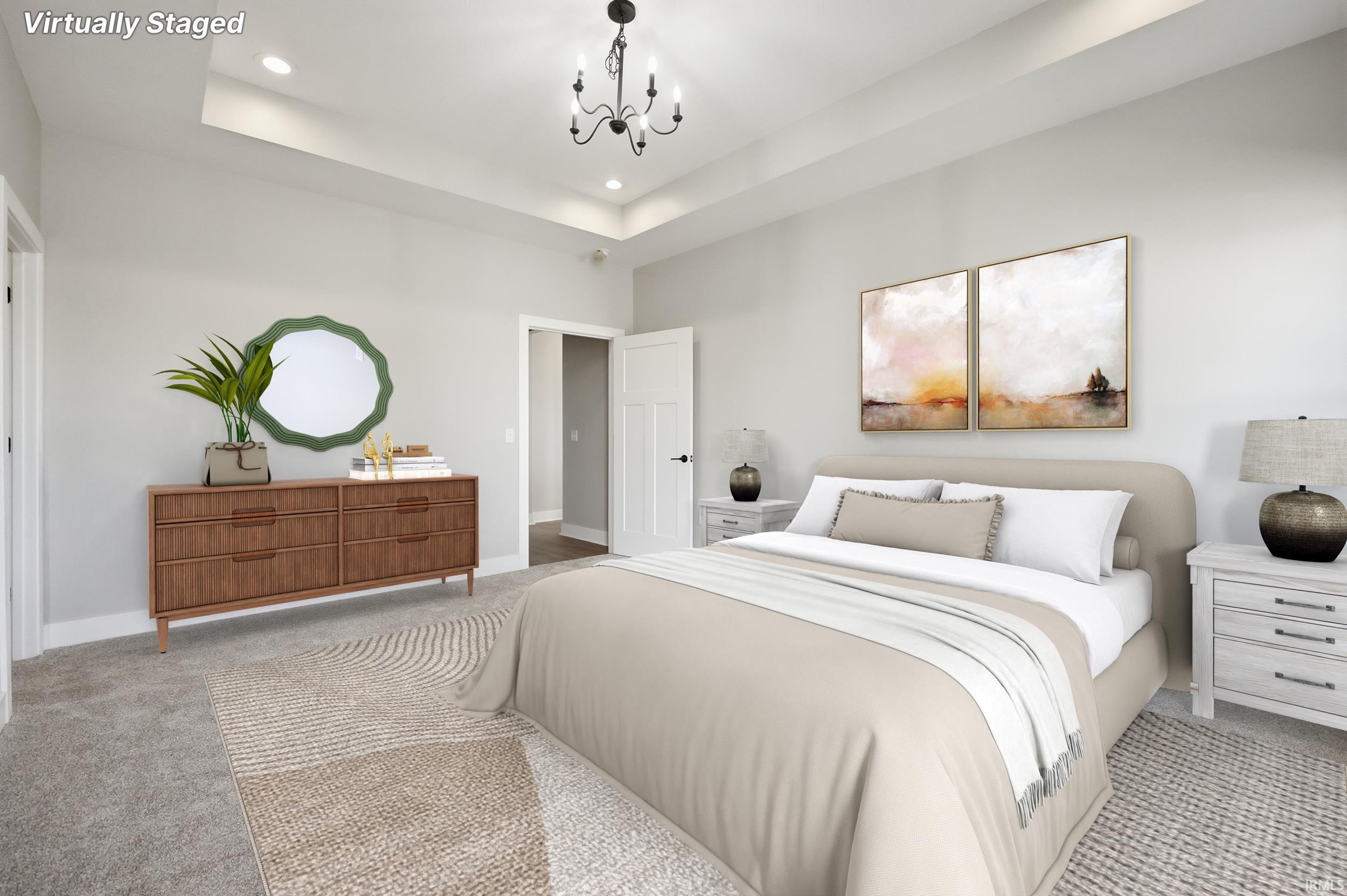 Spacious bedroom featuring a tray ceiling, recessed lighting, and a black chandelier
