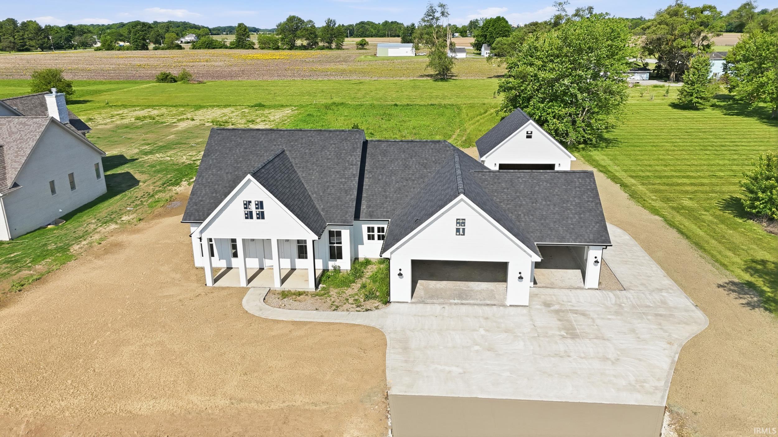 Modern farmhouse-style home featuring a dark shingle roof and white siding