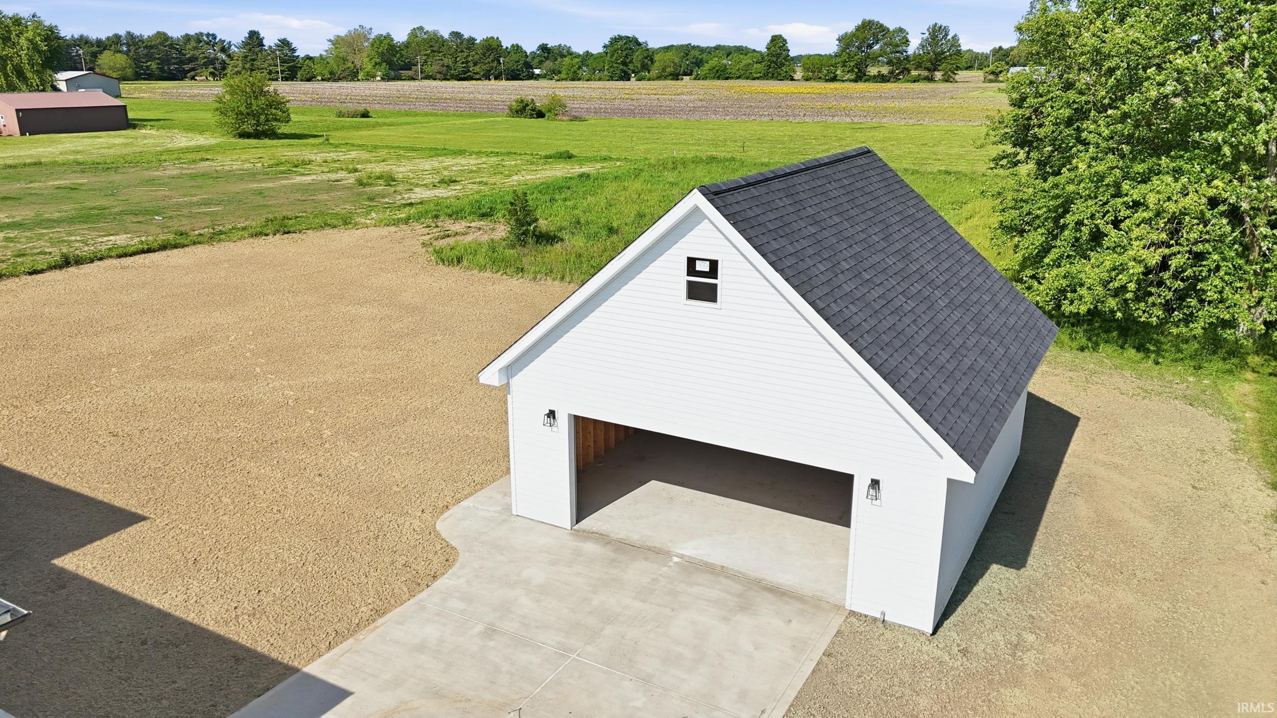 Detached two-car garage with white siding and dark shingle roof