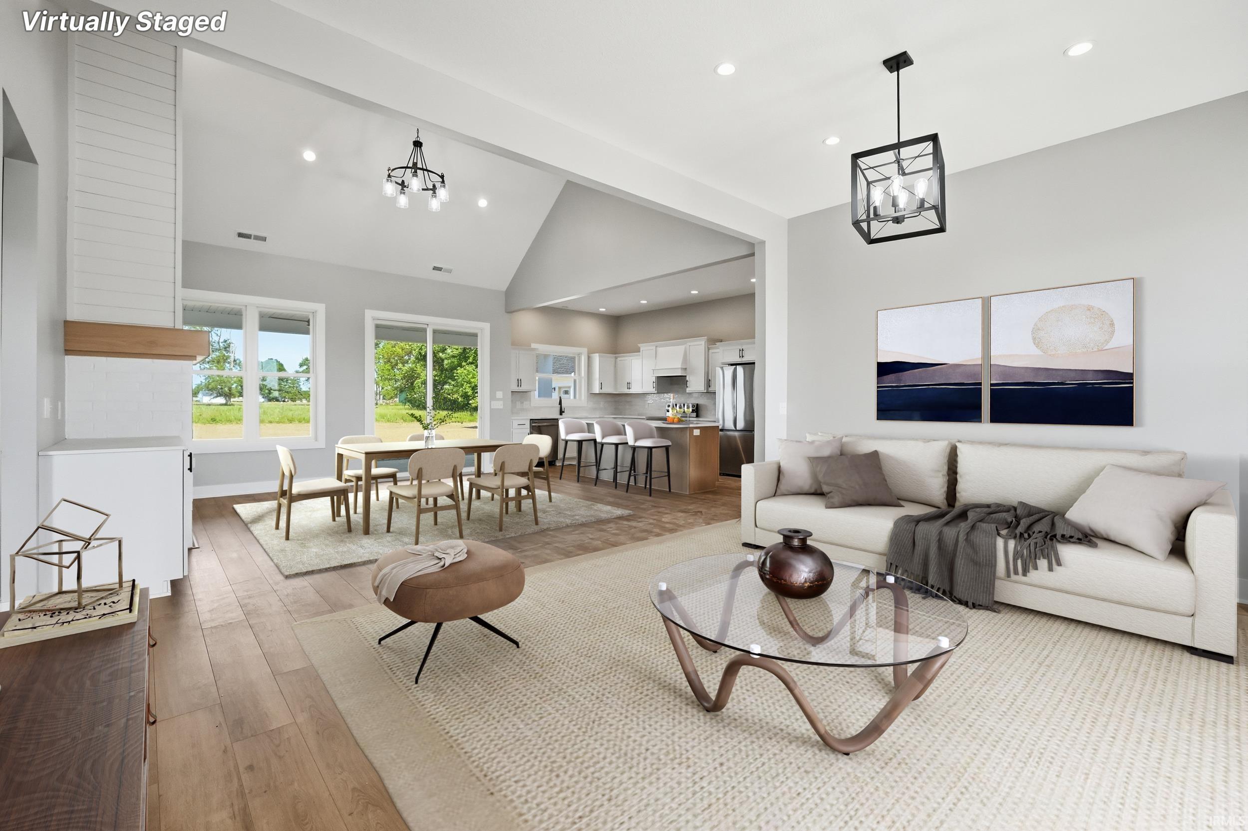 Open-concept living space featuring wood-finish flooring, recessed lighting, and vaulted ceilings