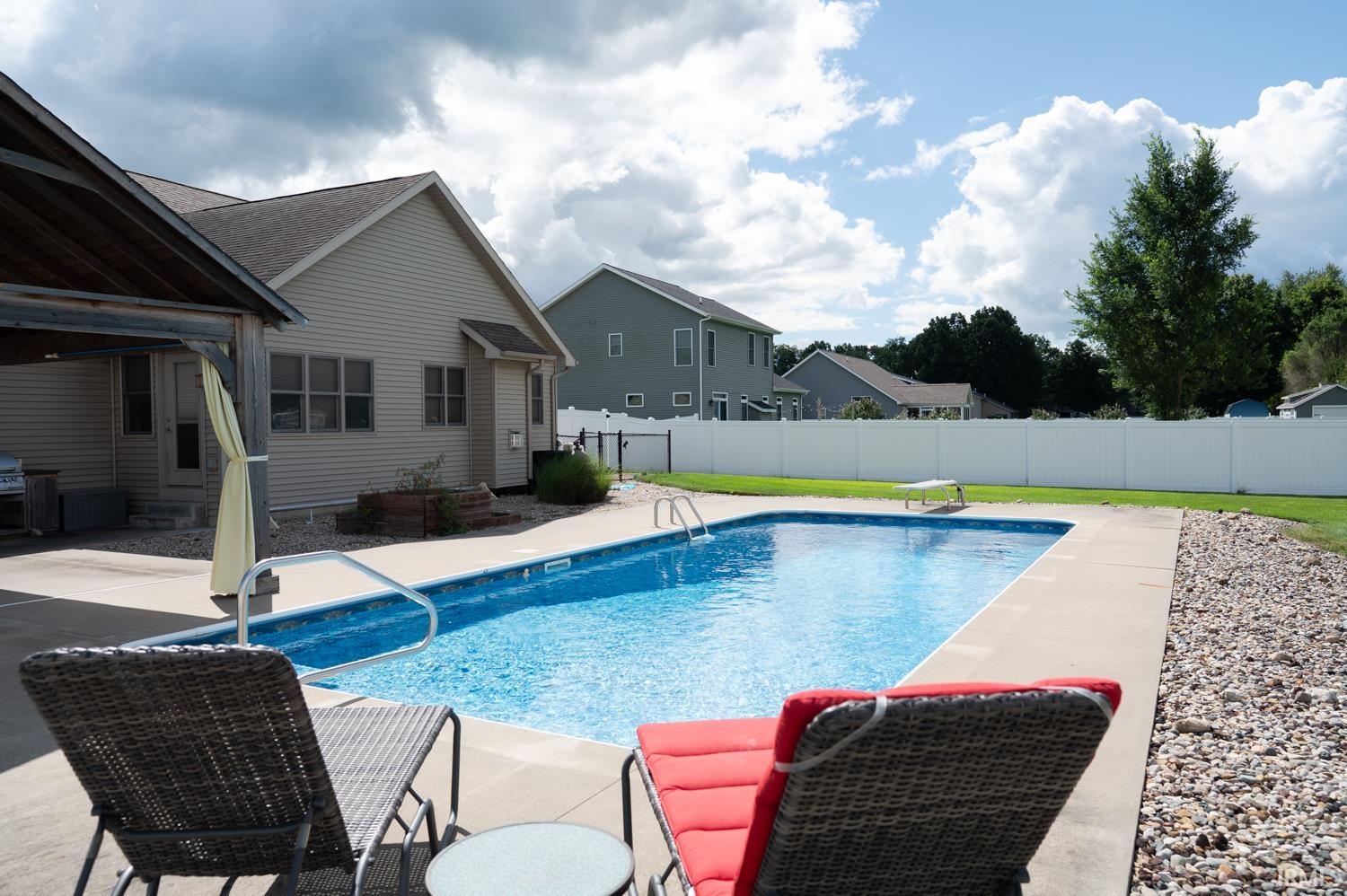 In-ground swimming pool featuring a concrete surround and integrated steps