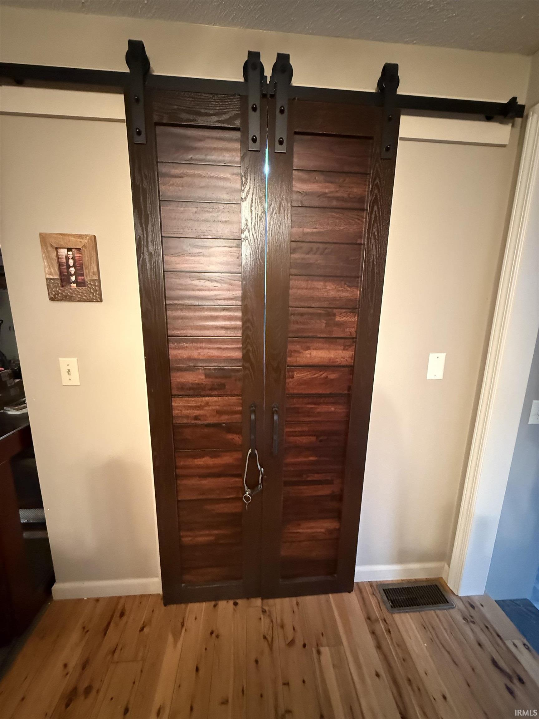 Double barn doors with dark wood panels and black matte hardware